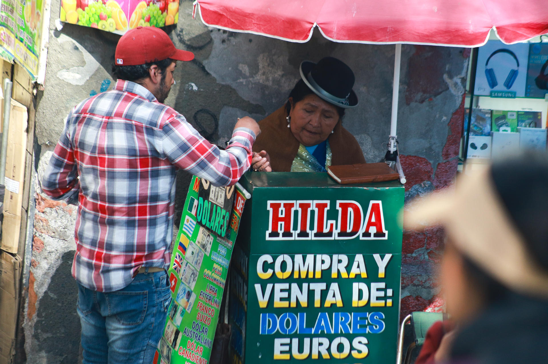 Una hombre realiza el cambio de divisas este jueves, en el centro de La Paz (Bolivia). EFE/ Gabriel Márquez