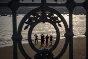 Varios nadadores se dirigen al agua en la playa de Ondarreta de San Sebastián a primera hora de este lunes. EFE/Javier Etxezarreta