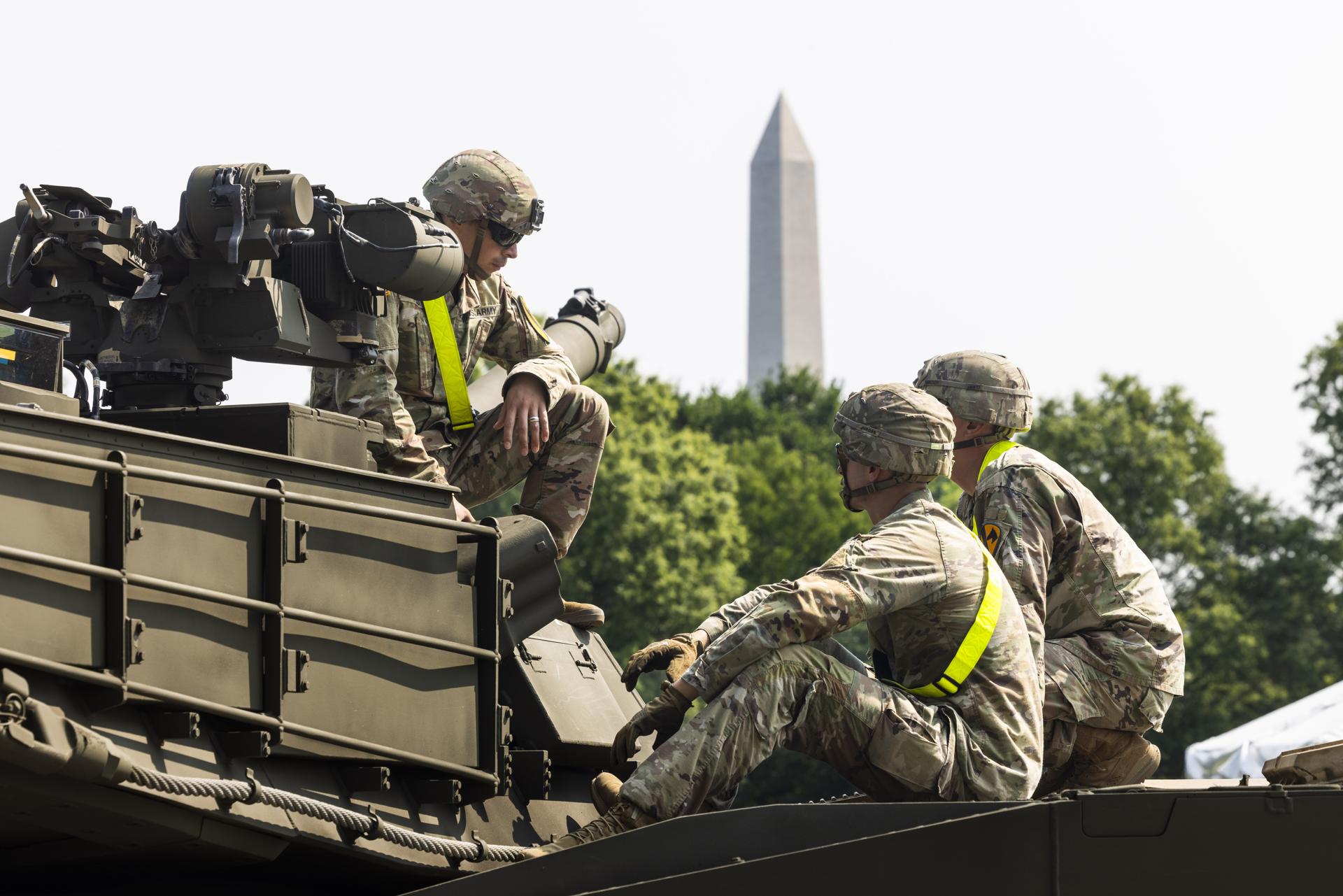 Soldados estadounidenses sobre un tanque Abrams que se encuentra en el Parque West Potomac antes de un desfile militar el 14 de junio en Washington. EFE/EPA/JIM LO SCALZO