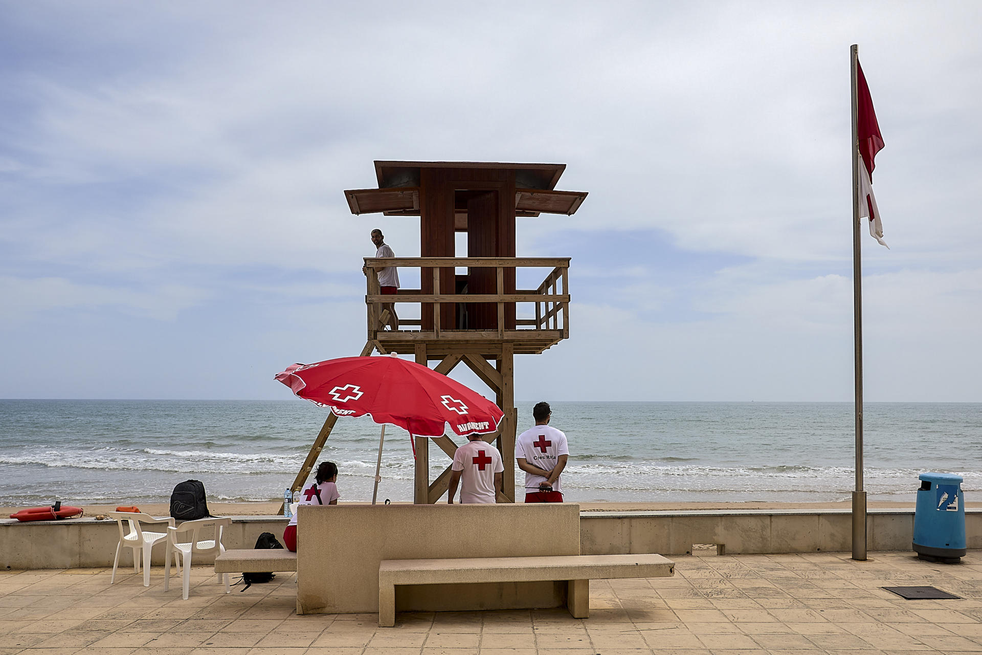 Unos socorristas aguardan en la playa cerrada de Bellreguard que mantiene la prohibición de acceso por el posible vertido marino, que está siendo analizado. EFE/ Natxo Francés