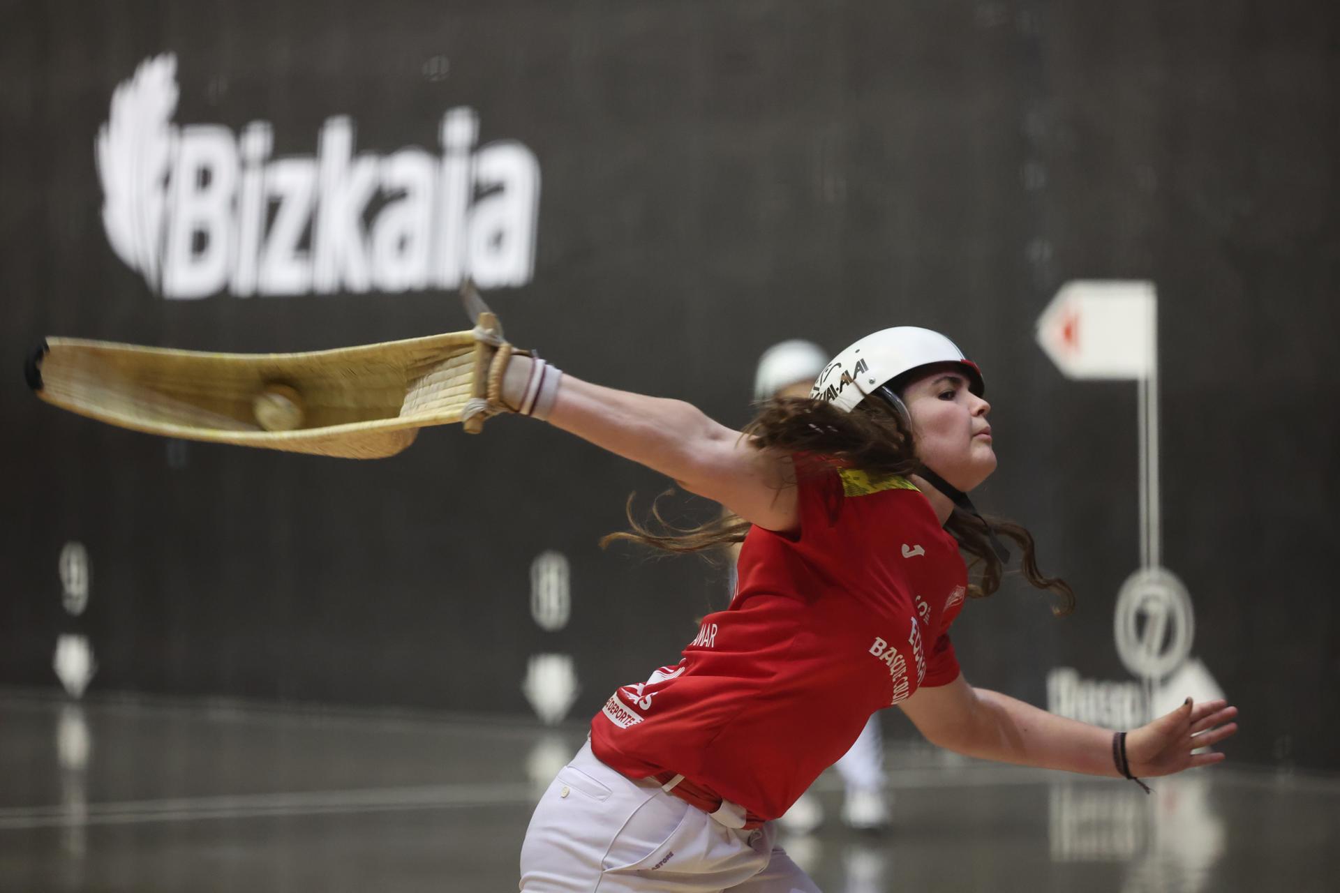 La española Erika Mugartegui en partido frente a las mexicanas naturales de Puebla, Maria Fernanda Ballesteros (zaguera) y Tania Mayorga Arai Lejardi en la segunda jornada de la I Liga de Naciones de cesta punta en frontón de 54 metros, primer torneo oficial en el que competirá el combinado vasco tras su reconocimiento internacional, ha enfrentado este lunes en Gernika a Mexico (azul ) contra España (rojo ) en categoría femenina. EFE/Luis Tejido
