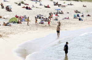 Varias personas se refrescan en la playa de Doniños, este miércoles. EFE/ Kiko Delgado