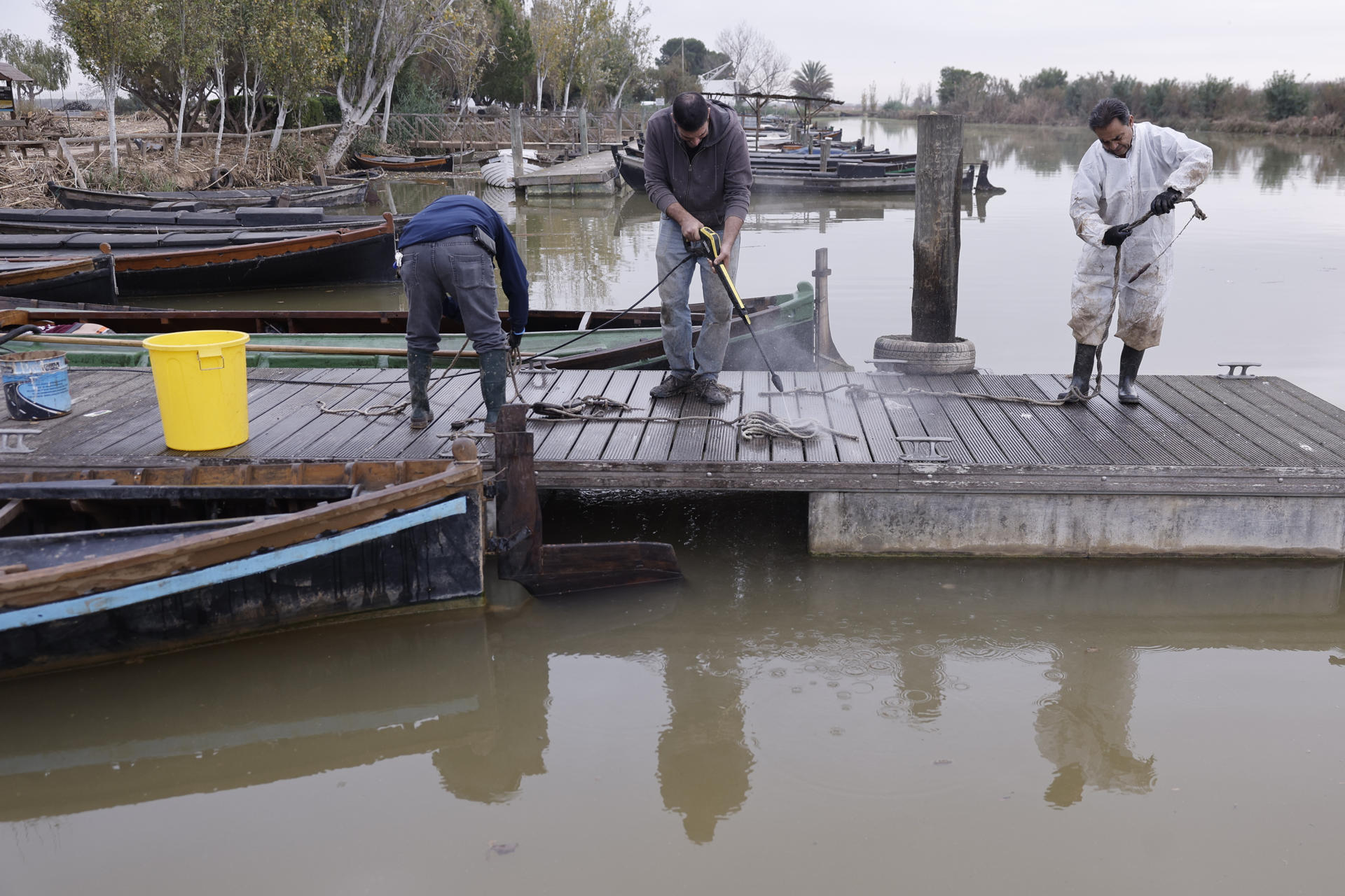 En la imagen de archivo, varias personas limpian las barcas y utensilios en el puerto de la Albufera en Catarroja. EFE/ Kai Forsterling