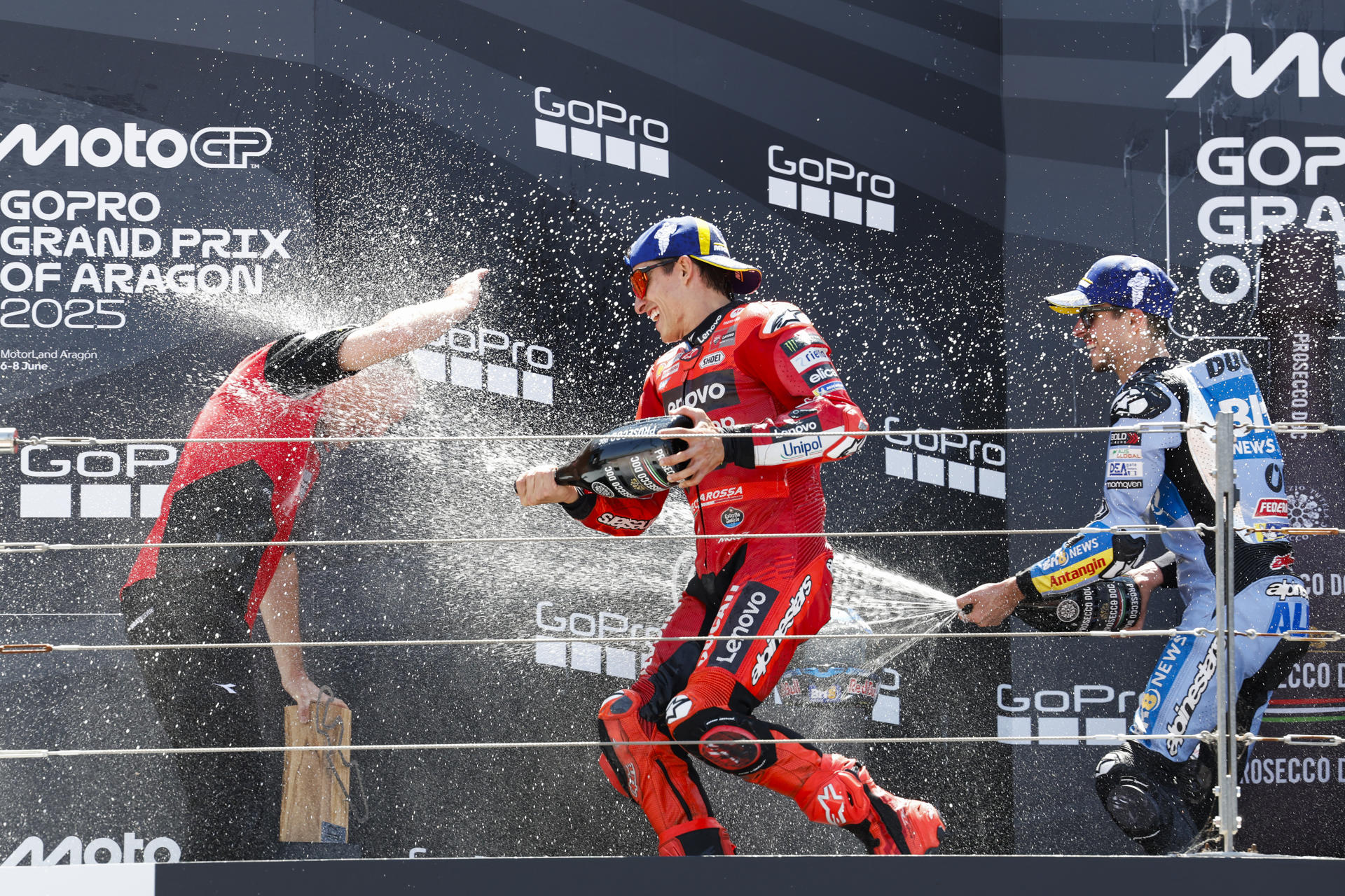 El piloto Marc Márquez (c), de Ducati Lenovo Team, primer clasificado, su hermano Álex Márquez (i), segundo, y el italiano Francesco Bagnaia (d), tercero en el podio tras la carrera de MotoGP del Gran Premio de Aragón en el circuito Motorland de Alcañiz (Teruel), este domingo. EFE/Javier Cebollada