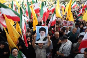 Un iraní sostiene un retrato del líder supremo iraní, el ayatolá Alí Jamenei, entre banderas nacionales de Irán durante una manifestación en Teherán, Irán, el 24 de junio de 2025. EFE/ABEDIN TAHERKENAREH