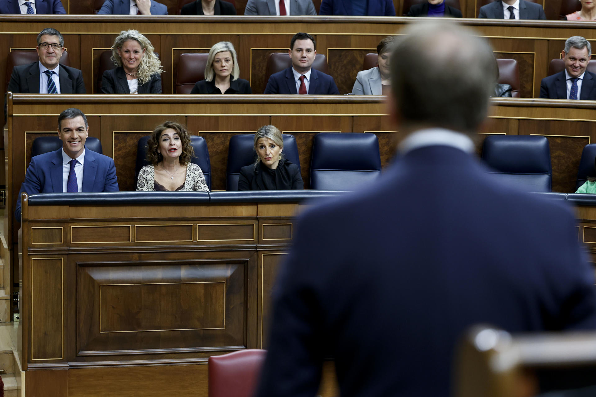 Imagen de archivo (13/03/2024) del presidente del PP, Alberto Núñez Feijóo (de espaldas) dirigiéndose al presidente del Gobierno, Pedro Sánchez, durante una sesión de control al Gobierno en el Congreso. EFE/Chema Moya