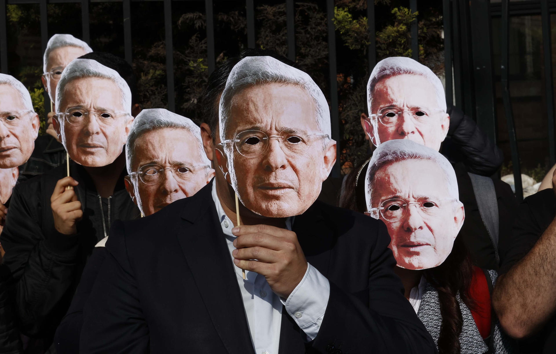 Fotografía de archivo, tomada en febrero pasado, en un grupo de personas al usar mascaras con la imagen del expresidente colombiano Álvaro Uribe (2002-2010), en el complejo judicial de Paloquemao, en Bogotá (Colombia). EFE/Mauricio Dueñas