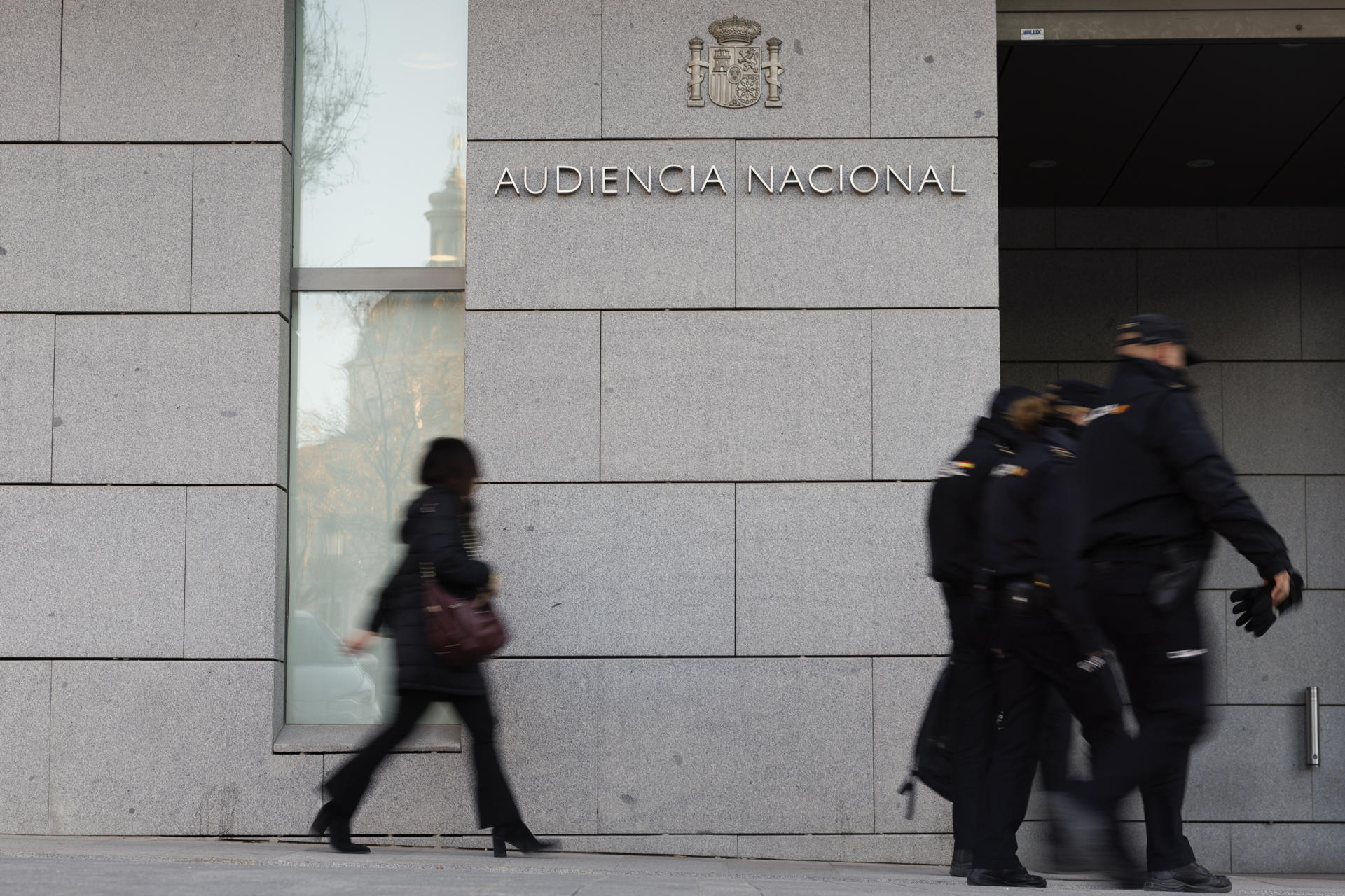 Un grupo de agentes de la Policía Nacional pasan delante de la entrada a la Audiencia Nacional. EFE/Sergio Pérez