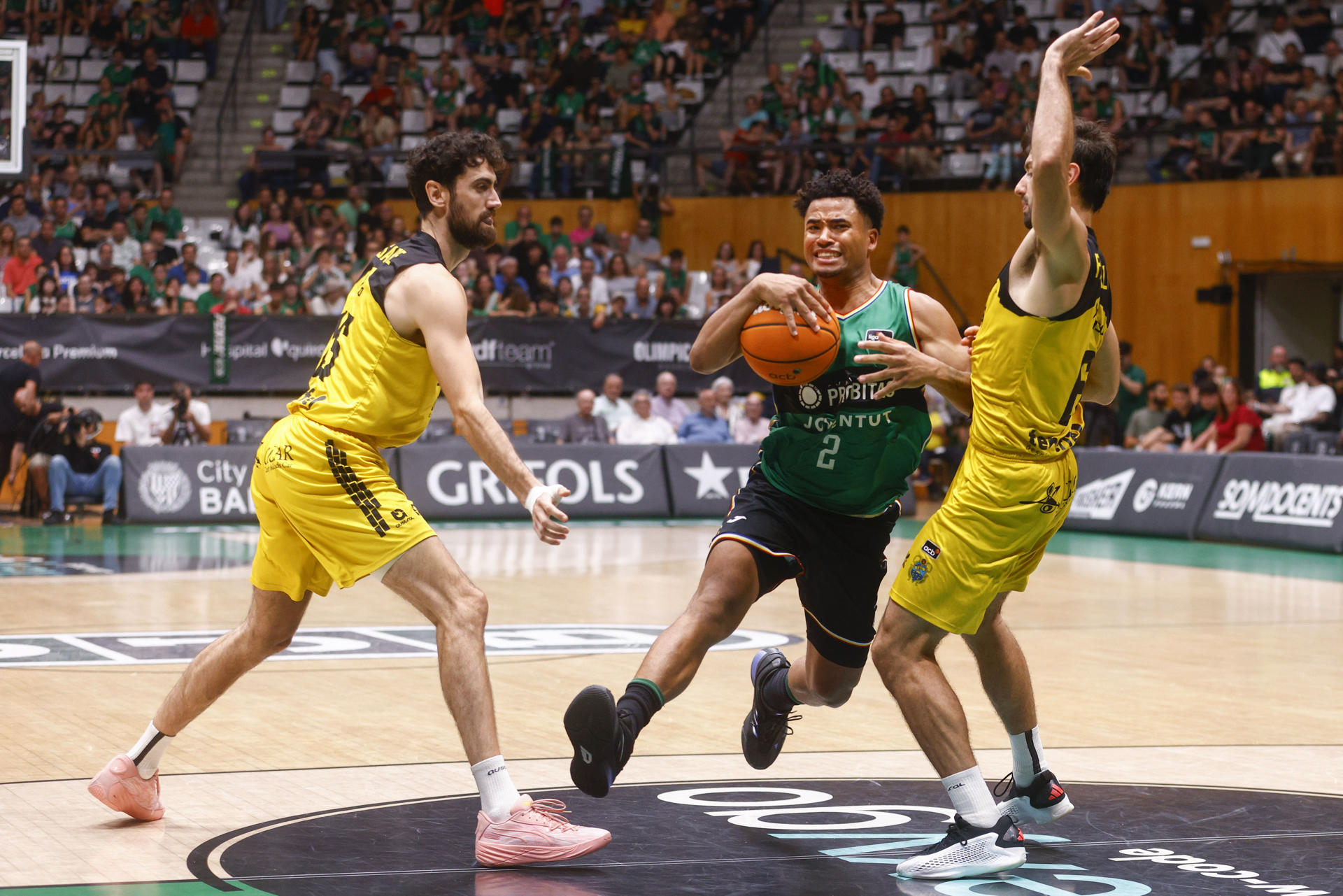 El base uruguayo de La Laguna Tenerife Bruno Fitipaldo (d) lucha con el base norteamericano del Joventut de Badalona Devon Dotson (c) durante el segundo partido de la eliminatoria de los cuartos de final de la Liga Endesa, entre el Joventut y La Laguna Tenerife, disputado este miércoles, en el Pabellón Olímpico de Badalona (Barcelona).EFE/ Quique García