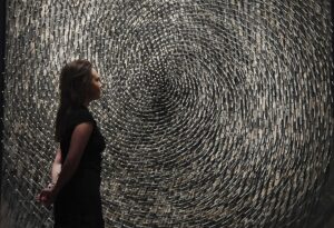 Imagen de archivo en la que una empleada de la casa Christie's contempla en Londres la obra "Spirale" del artista alemán Günther Uecker, fallecido este martes. EFE/Andy Rain