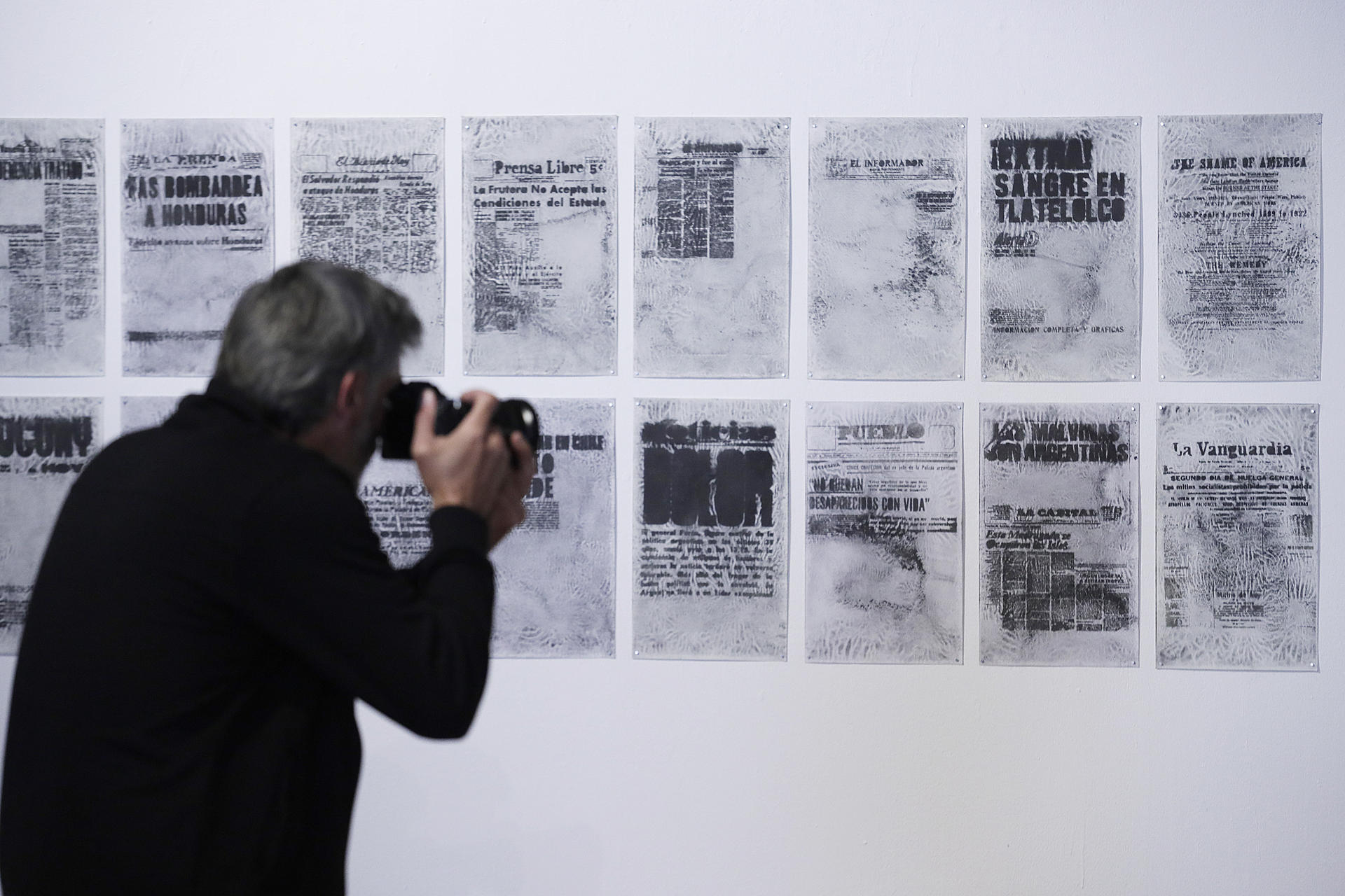 Un hombre toma una fotografía en la exposición colectiva ‘Laberintos de la Memoria’ este jueves, en el Museo de Arte Moderno de Bogotá (Colombia). EFE/Carlos Ortega