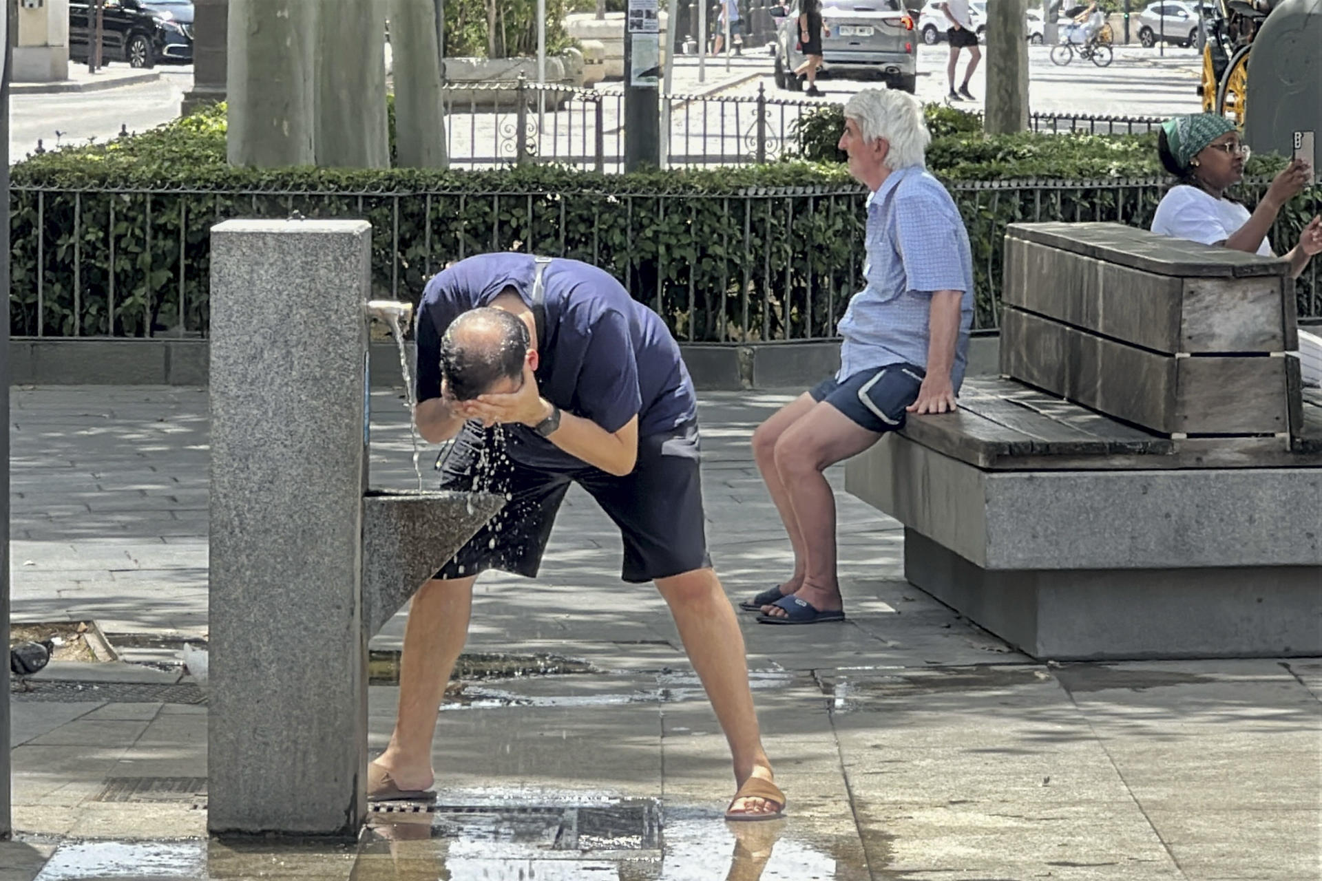 Un hombre se refresca en una fuente de Sevilla donde este domingo se han registrado más de 40 grados de temperatura. EFE/David Arjona
