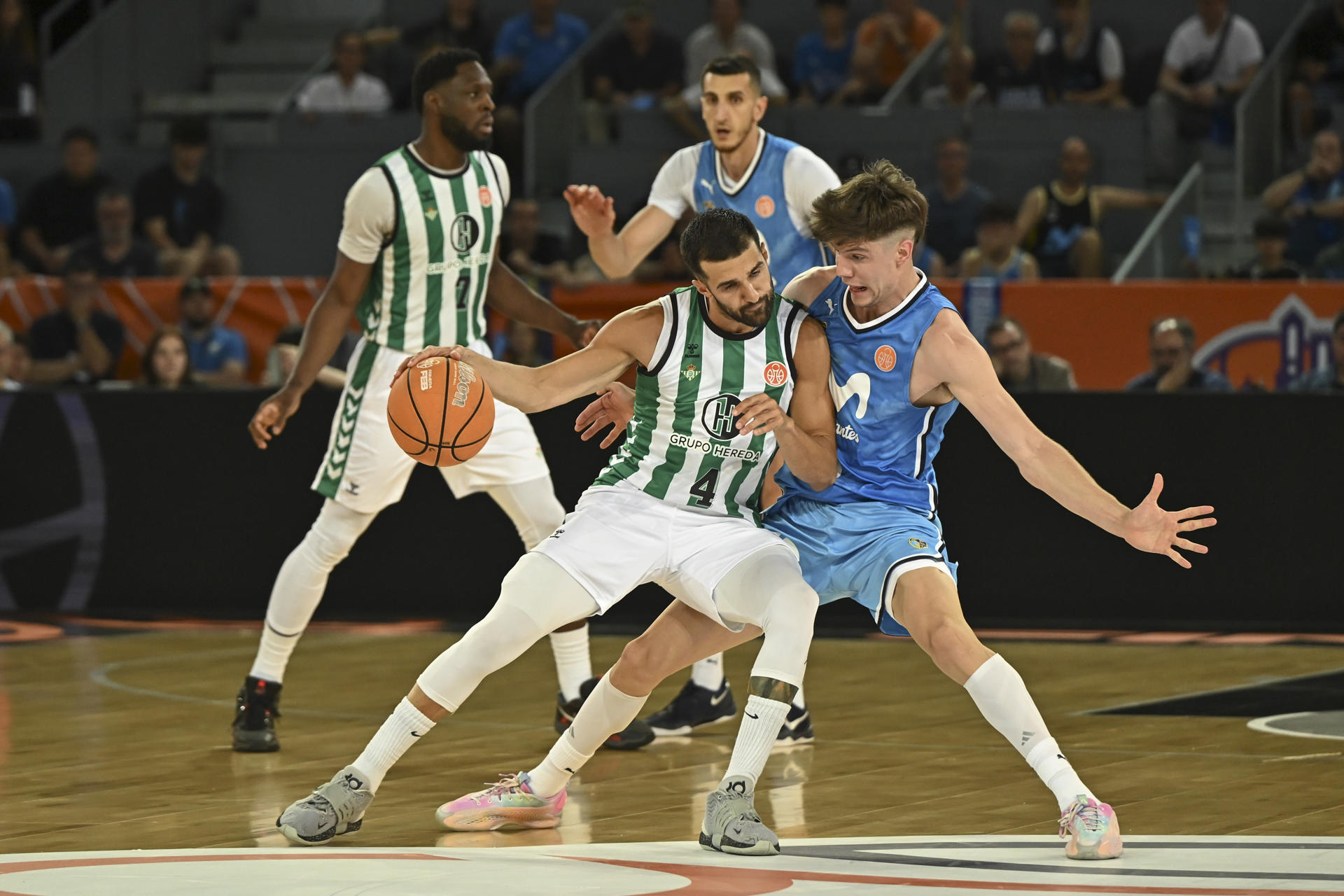 El base del Real Betis Aleksandar Cvetkovic (i) durante el partido de la primera semifinal de la Final Four de asceso a Liga Endesa disputado este sábado en la Caja Mágica, en Madrid. Es la primera vez desde que la segunda plaza de ascenso desde la Primera FEB se dirime en el formato de ‘final four’ que los cuatro aspirantes han tenido experiencia en la máxima competición del baloncesto. EFE/Fernando Villar
