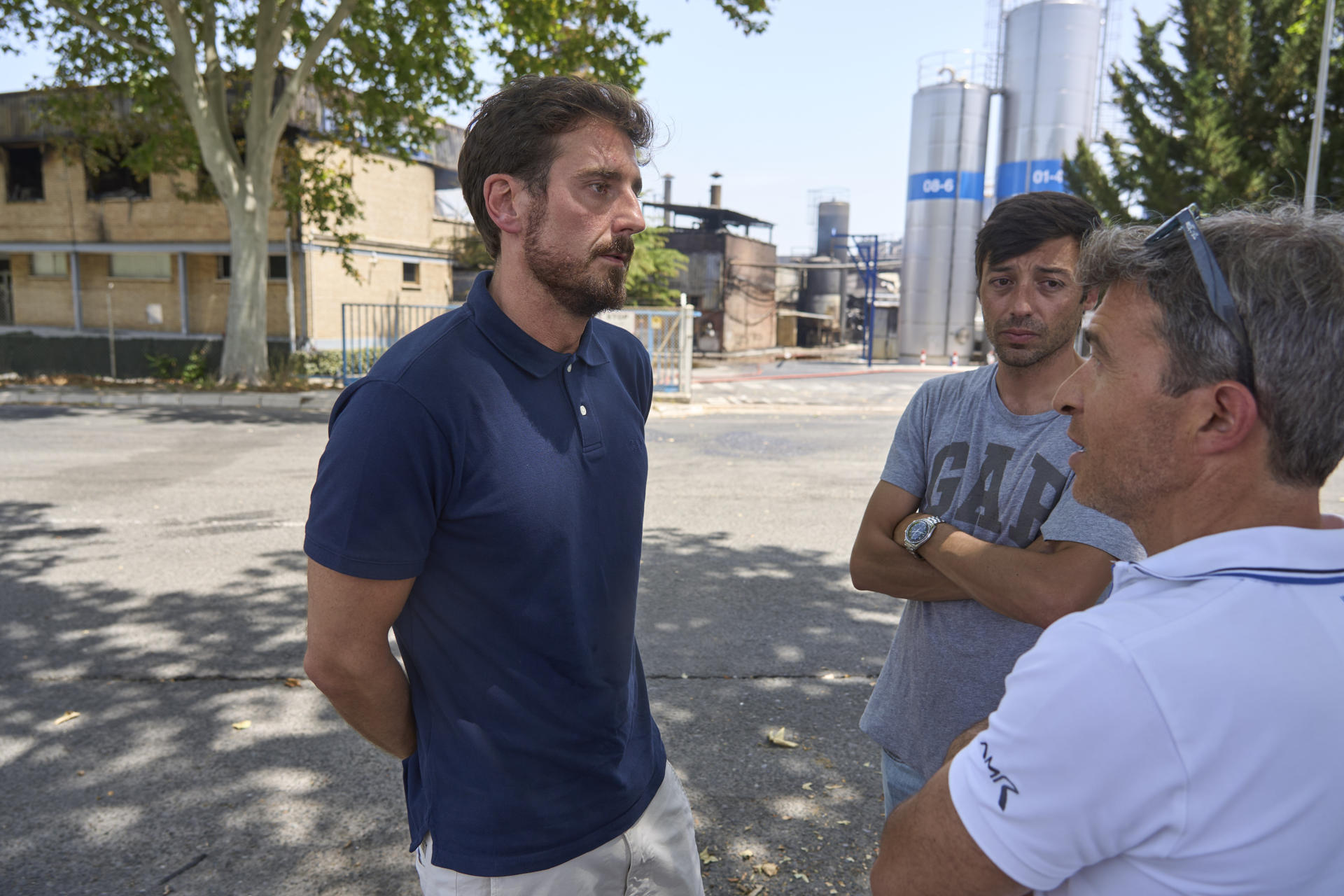 El CEO de la compañía familiar alavesa Lascaray-LEA, Félix Lascaray (i), conversa con trabajadores delante de la fábrica que sufrió ayer viernes un grave incendio, este sábado en Vitoria. El incendio sin heridos desatado ayer en la fábrica de productos de higiene personal LEA en Vitoria está controlado, aunque no extinguido totalmente, por lo que efectivos de los bomberos mantienen activa una línea de agua para apagar cualquier posible pequeño conato de fuego que pudiese reactivarse. EFE/ L. Rico