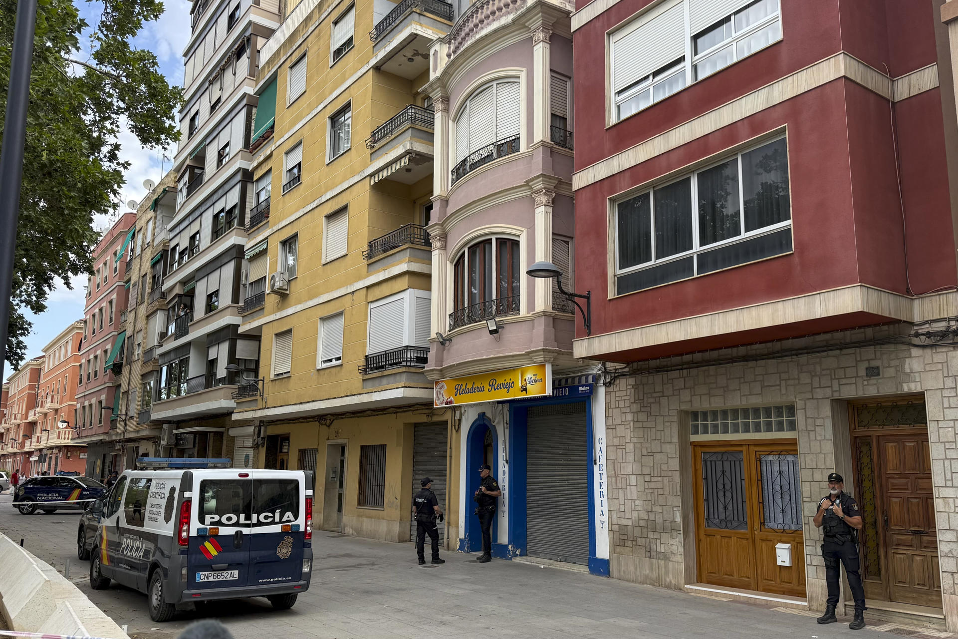 Agentes de la Policía Nacional aguardan ante la vivienda donde un hombre de 34 años ha asesinado presuntamente a su mujer y a su hijo de 3 años en la localidad de Algemesí (Valencia), según ha confirmado el cuerpo policial. EFE/Raquel Segura