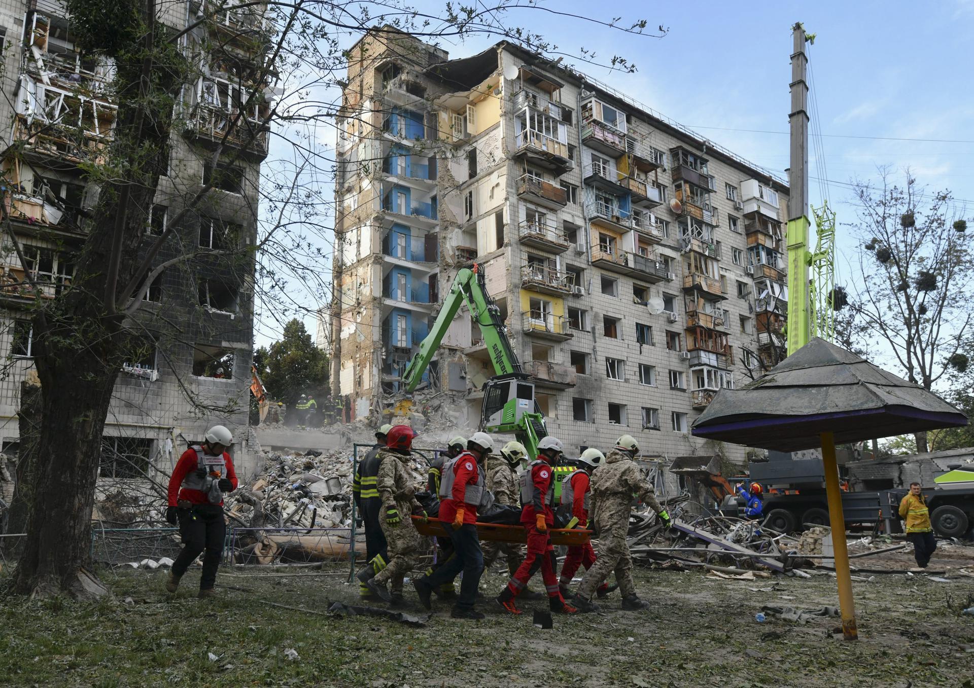 Rescatistas ucranianos fueron captados este martes, 17 de junio, al trasladar el cuerpo de una víctima fatal de un ataque aéreo ruso nocturno contra un edificio residencial de nueve pisos, en Kiev (Ucrania) EFE/Maxym Marusenko
