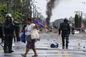 Civiles y policías fueron captados este domingo, 22 de junio, en una calle bloqueada durante una nueva jornada de protestas, en Changuinola (Bocas del Toro, Panamá). EFE/Bienvenido Velasco