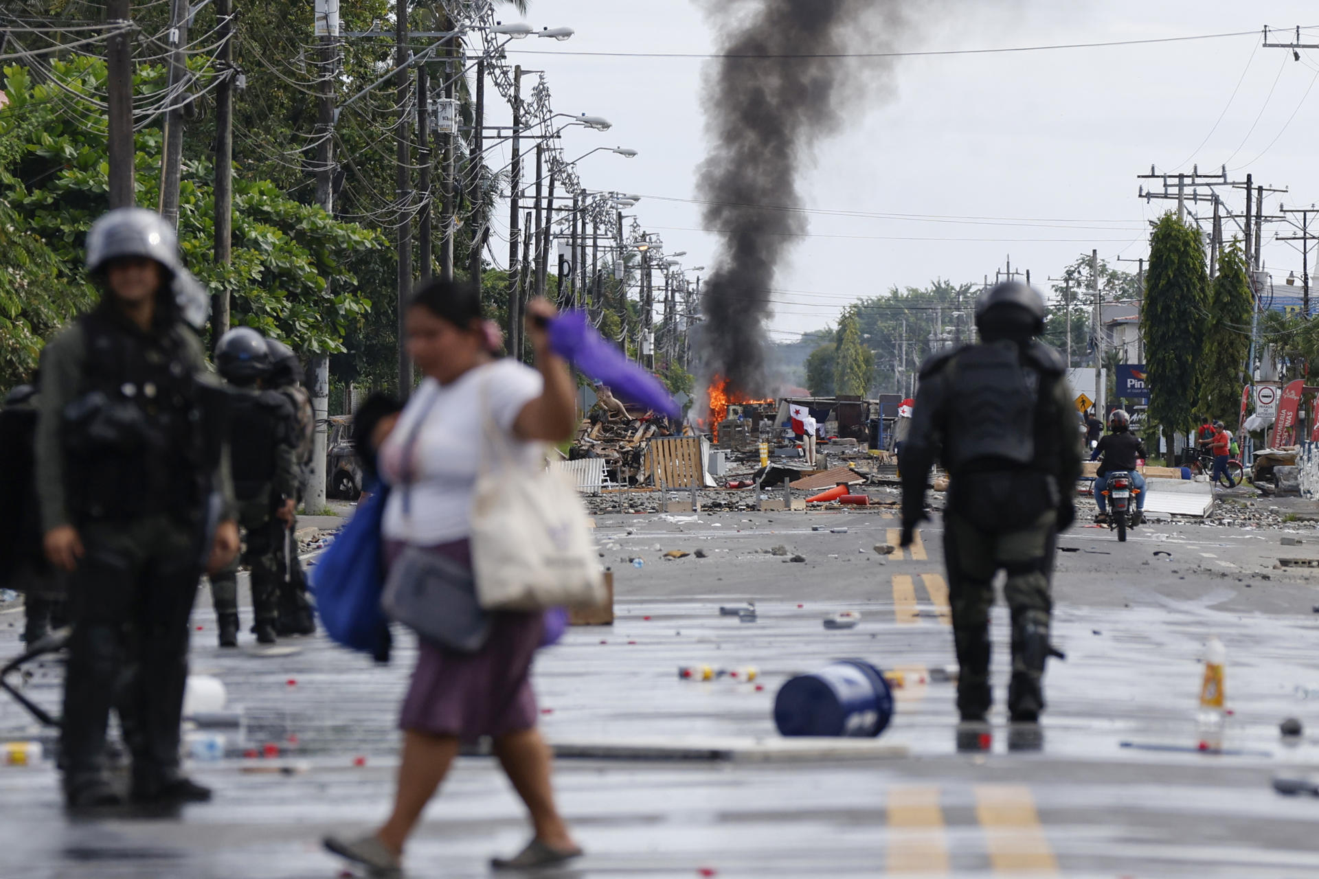Civiles y policías fueron captados este domingo, 22 de junio, en una calle bloqueada durante una nueva jornada de protestas, en Changuinola (Bocas del Toro, Panamá). EFE/Bienvenido Velasco