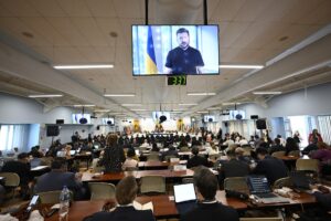 Fotografía cedida por la Organización de los Estados Americanos (OEA) donde aparece el presidente ucraniano, Volodímir Zelenski (en pantalla), hablando en un mensaje en video emitido durante la Asamblea General celebrada este miércoles, en Saint John’s (Antigua y Barbuda). EFE/ Juan Manuel Herrera/OEA