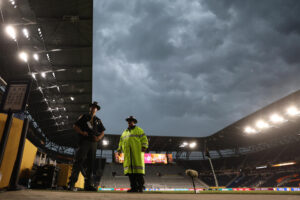 Integrantes de la Policía de Cincinnati se resguardan de la lluvia este miércoles durante el partido del Mundial de Clubes entre Pachuca y Red Bull Salzburgo que fue suspendido en el minuto 53 en el estadio TQL de Cincinnati. EFE/ Juan Ignacio Roncoroni