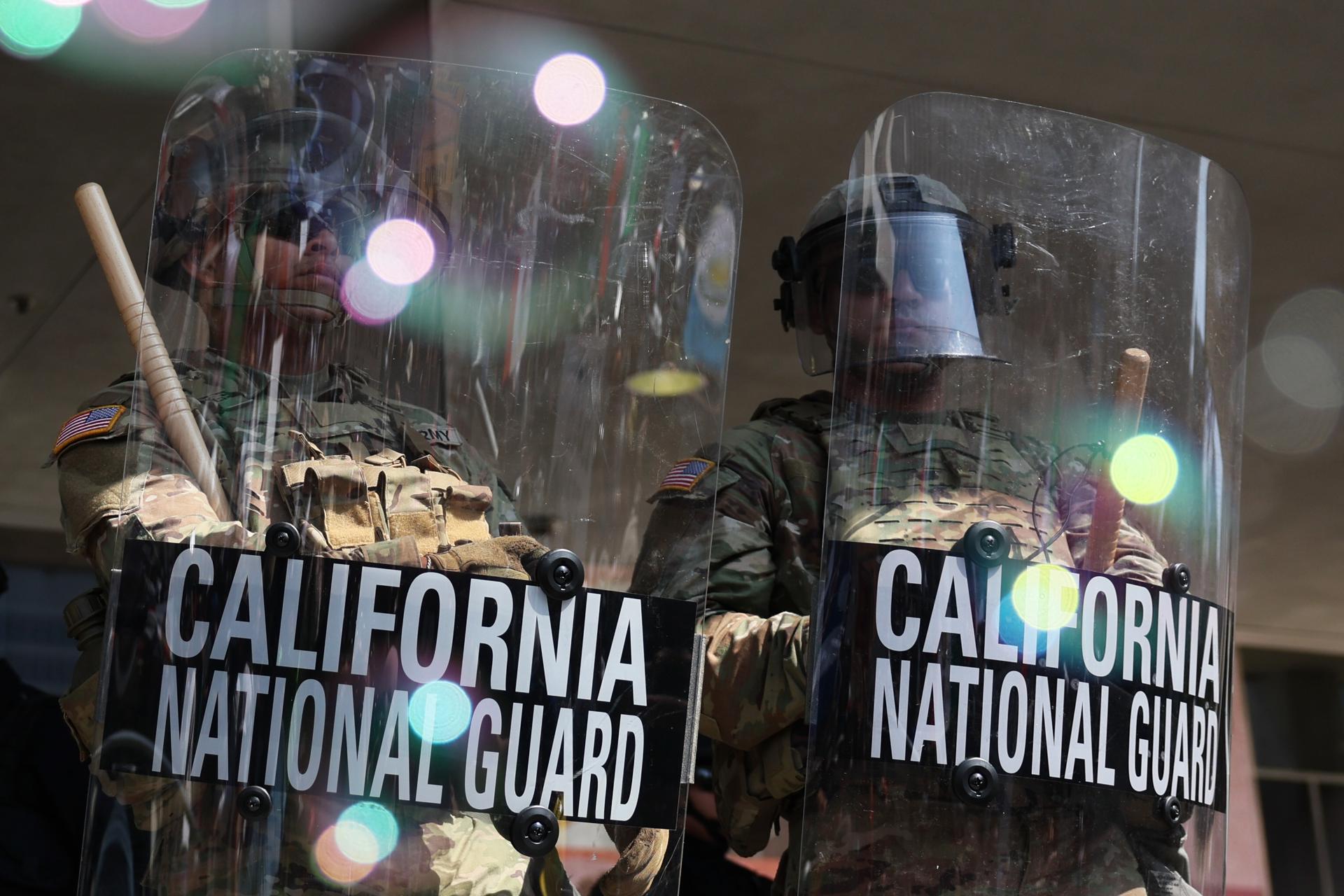Miembros de la Guardia Nacional de California fueron captados este martes, 10 de junio, al custodiar el edificio federal, durante las protestas contra su presencia y las redadas a migrantes presuntamente indocumentados, en Los Ángeles (CA, EE.UU.). EFE/Allison Dinner
