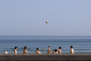 Unos jóvenes juegan con un balón este jueves en la playa de la Zurriola de San Sebastián (España). EFE/Juan Herrero