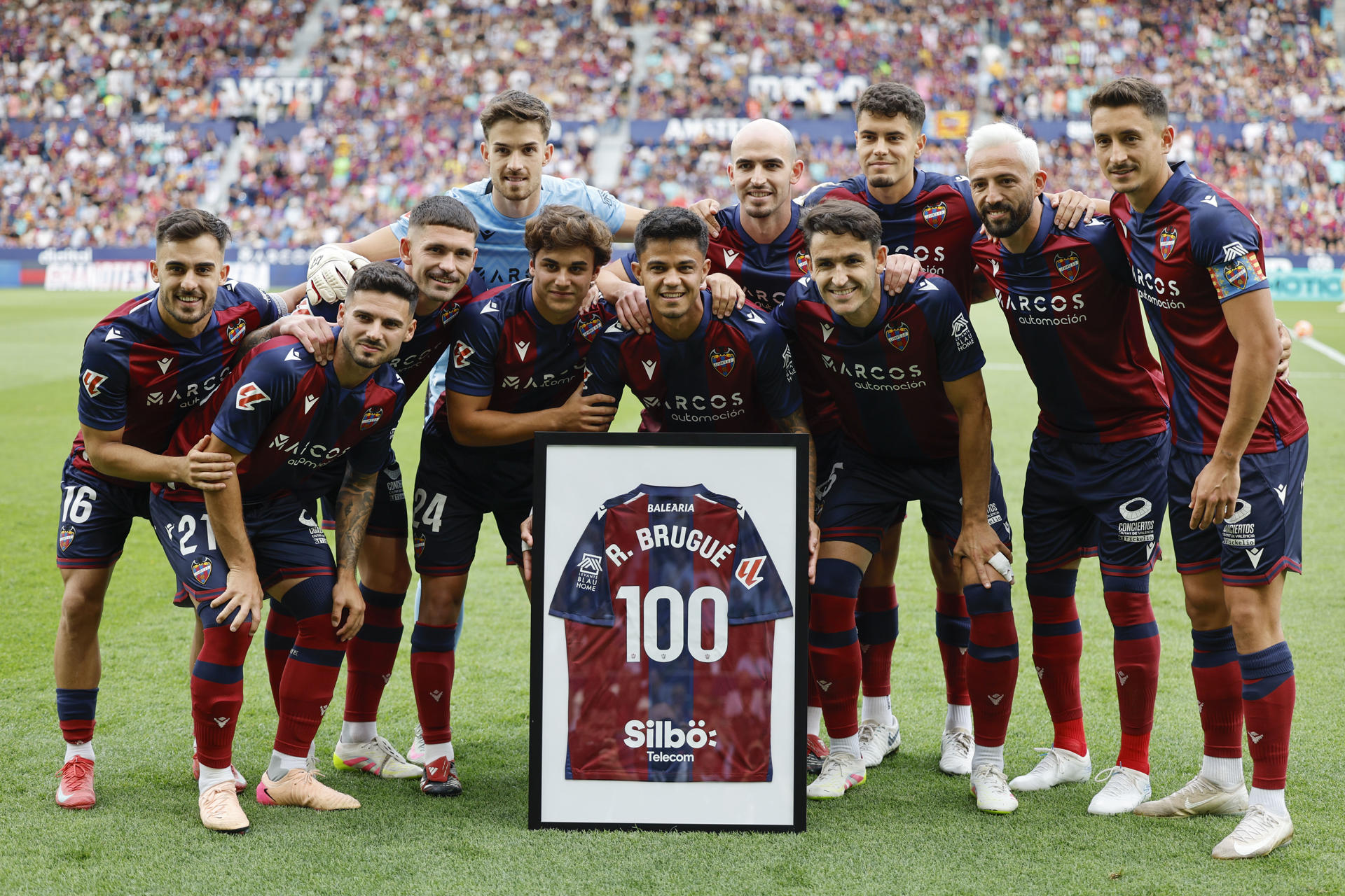 -El delantero Roger Brugué (c), recibe su camiseta tras unirse al grupo de jugadores que han disputado más de cien encuentros con el Levante UD, en el estadio Ciutat de Valencia.- EFE/ Ana Escobar