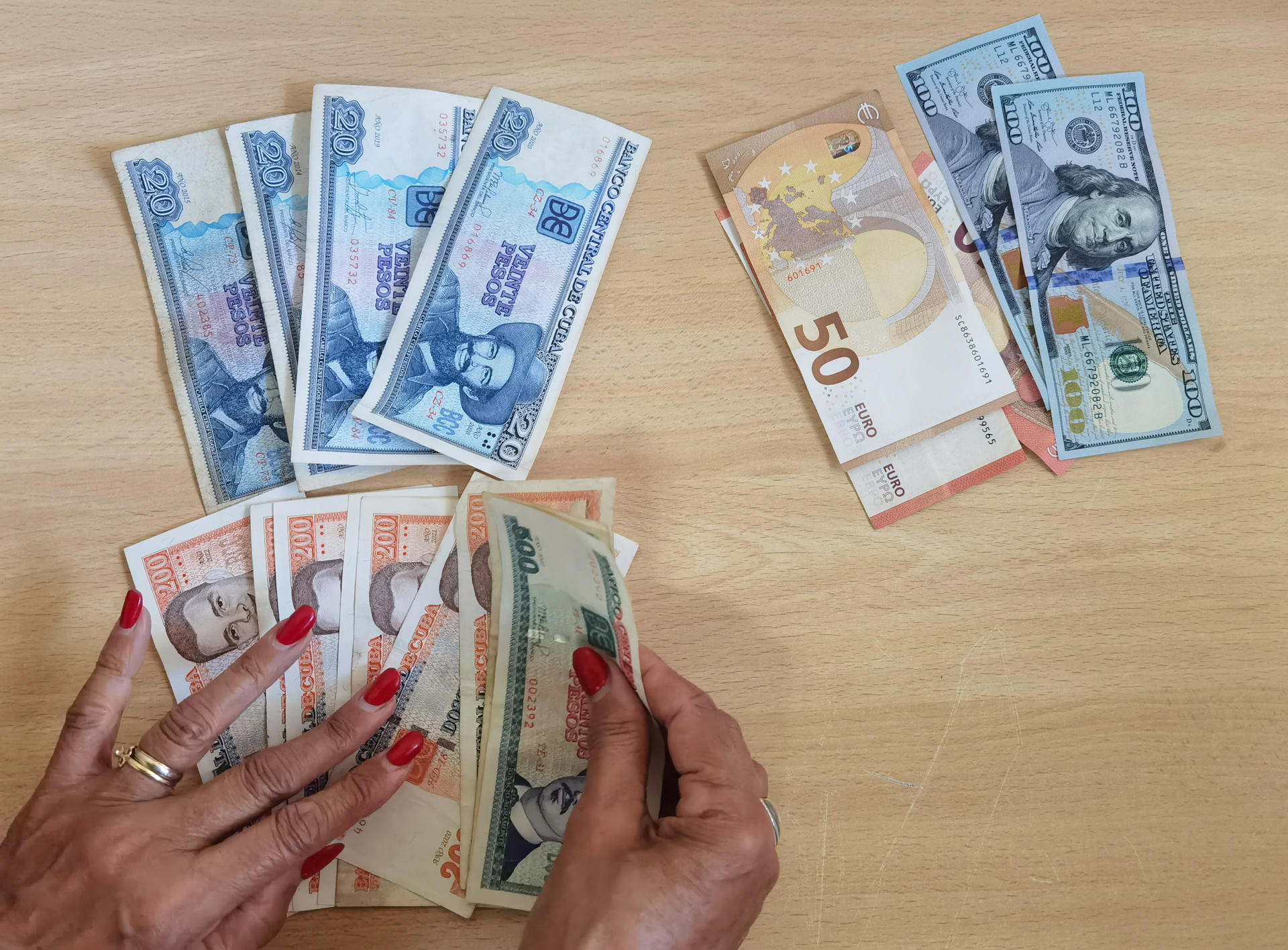 Fotografía de archivo de una persona que muestra billetes de dólares, euros y pesos cubanos en La Habana (Cuba). EFE/Yander Zamora