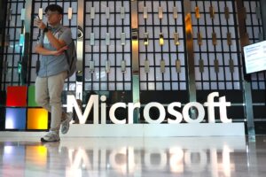 EA4187. BOGOTÁ (COLOMBIA), 17/06/2025.- Fotografía de archivo del 2 de mayo de 2025 de un hombre caminando frente al logo de Microsoft durante el evento 'Microsoft Build' :Día de la IA en Kuala Lumpur (Malasia). Una de las alianzas más importantes en la inteligencia artificial (IA), la del gigante tecnológico Microsoft y OpenAI, una de las empresas pioneras en esta tecnología, parece peligrar y depende ahora de unas tensas negociaciones entre ambos gigantes, de acuerdo con la prensa especializada. EFE/EPA/FAZRY ISMAIL /ARCHIVO