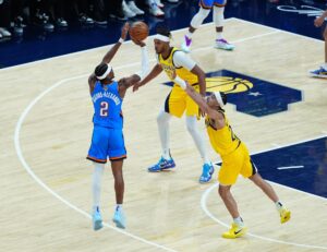 Shai Gilgeous- Alexander (d) de los Oklahoma City Thunder lanza con la marca de Andrew Nembhard (i) de los Indiana Pacers. EFE/Brian Spurlock