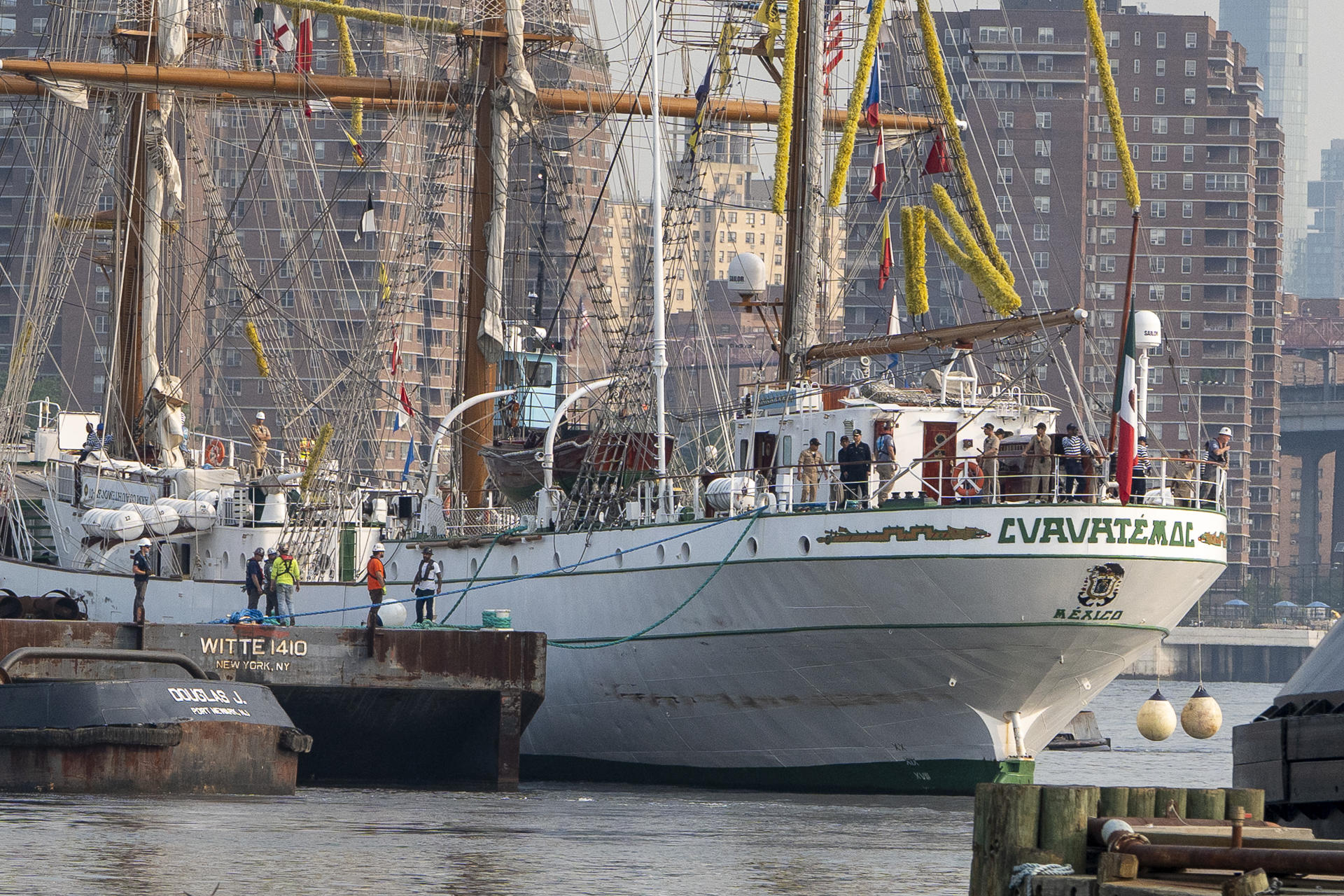 Personas participan en el traslado del buque escuela Cuauhtemoc, de la Armada Mexicana, desde el puerto 63 hasta Navy Yard, este viernes en Nueva York (EE.UU.). EFE/ Angel Colmenares
