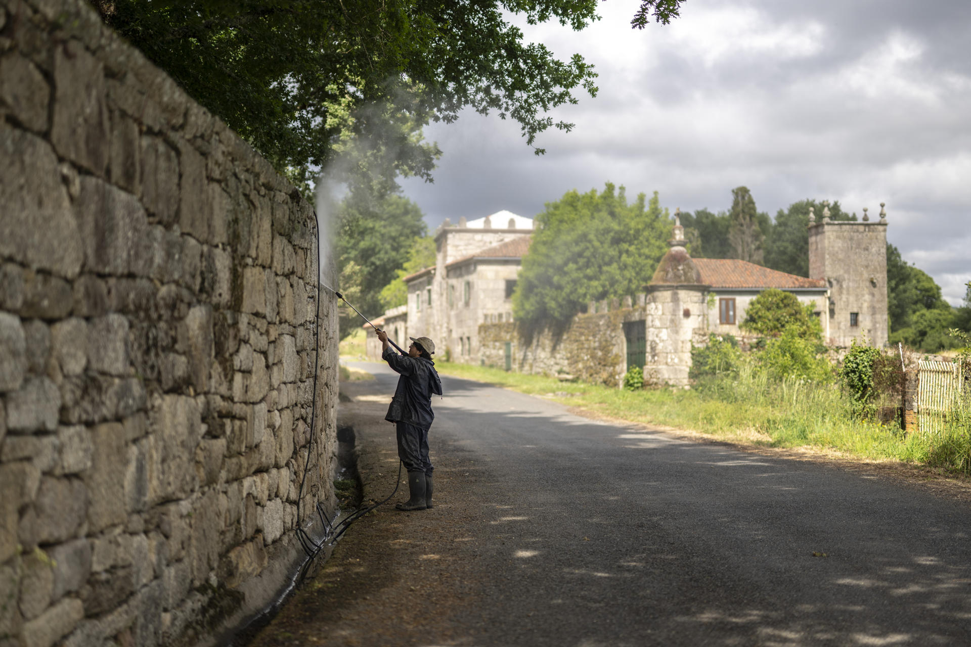 Un trabajador limpia el muro de la vivienda que ha comprado Julio Iglesias en Piñor (norte de España). EFE/ Brais Lorenzo
