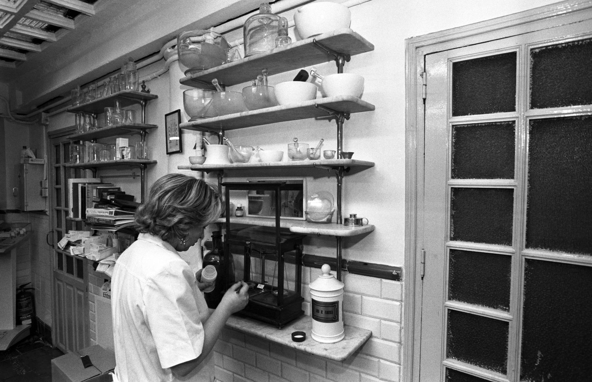 Imagen de archivo de una mujer pesando unos medicamentos en el interior de una farmacia. 
EFE/Cacho