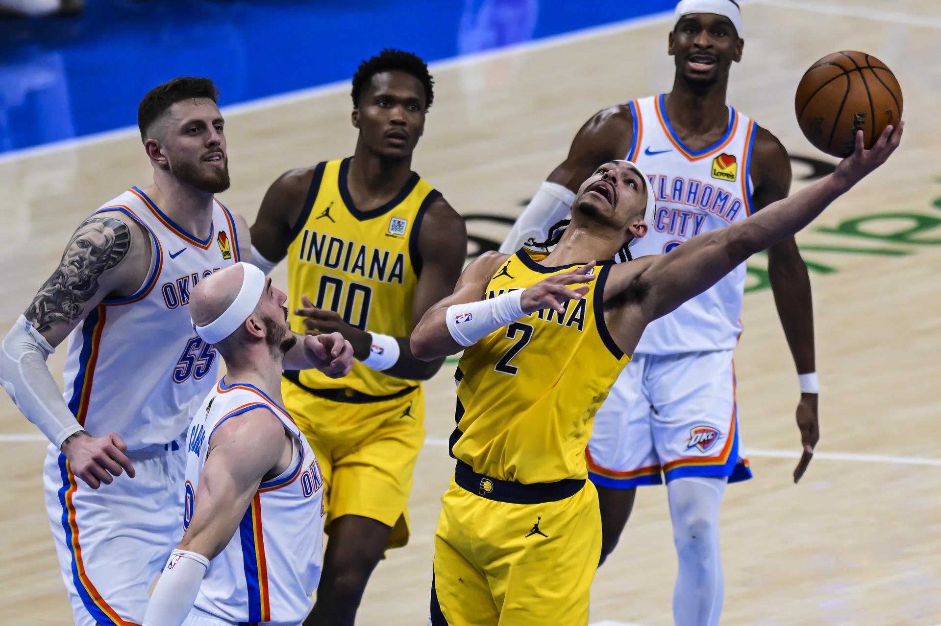 El escolta de Indiana Pacers Andrew Nembhard (2-d) tira a canasta durante el quinto partido de las Finales de la NBA que Oklahoma City Thunder ganó este lunes por 120-109 y con el que ha elevado a 3-2 su ventaja en la lucha por el anillo en el Paycom Center de Oklahoma. EFE/EPA/MANUELA SOLDI
