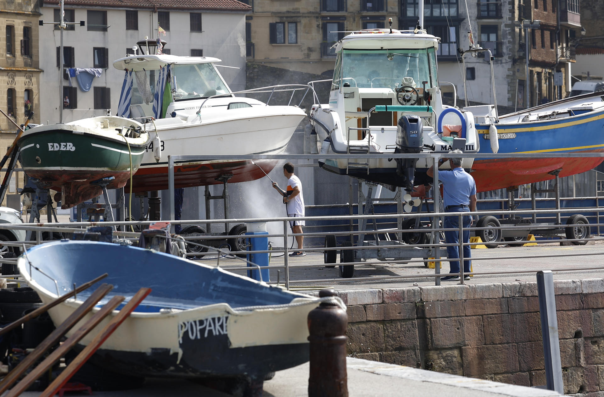 Un hombre prepara su embarcación para el verano este martes en el puerto pesquero de San Sebastián. EFE/Juan Herrero.