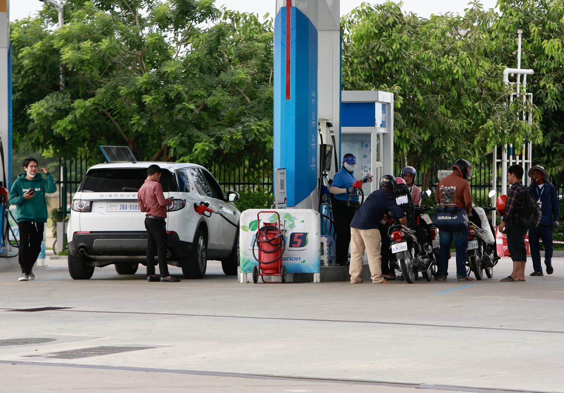 Un grupo de camboyanos reposta sus vehículos en una gasolinera de Nom Pen. EFE/EPA/KITH SEREY