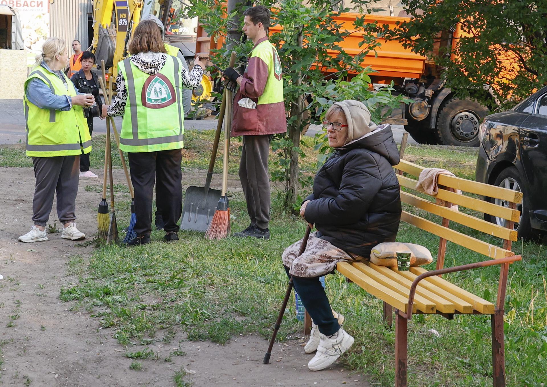 Una mujer espera cerca del lugar de un ataque con drones contra un edificio residencial en Járkov, noreste de Ucrania, el 12 de junio de 2025.EFE/EPA/SERGEY KOZLOV