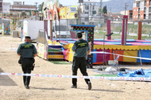 Agentes de la Guardia Civil precintan este domingo las camas elásticas del recinto ferial de la pedanía murciana de Alquerías después de que una niña de dos años falleciera esta madrugada al recibir una descarga eléctrica. EFE/ Juan Carlos Caval