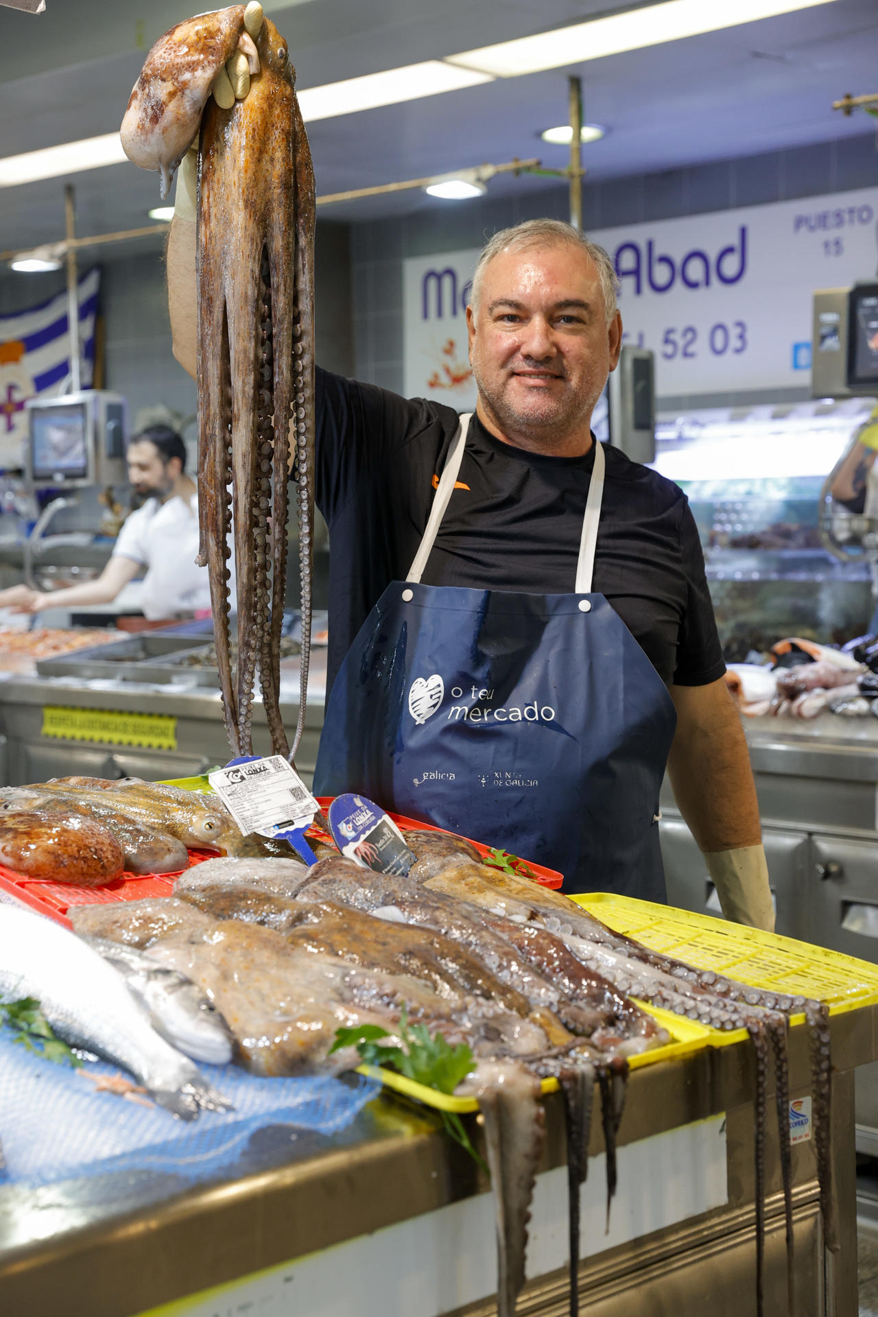 Uno de los placeros del mercado de la plaza de Lugo, en A Coruña, muestra un ejemplar de pulpo en el mercado de la plaza de Lugo, en A Coruña este viernes. El pulpo vive su mejor arranque de campaña en años en Galicia después de tres meses de parón, con capturas abundantes y de buena calidad que animan a pescadores y pescaderos y contrastan con el regreso moderado de la nécora tras seis meses de veda. EFE/Cabalar