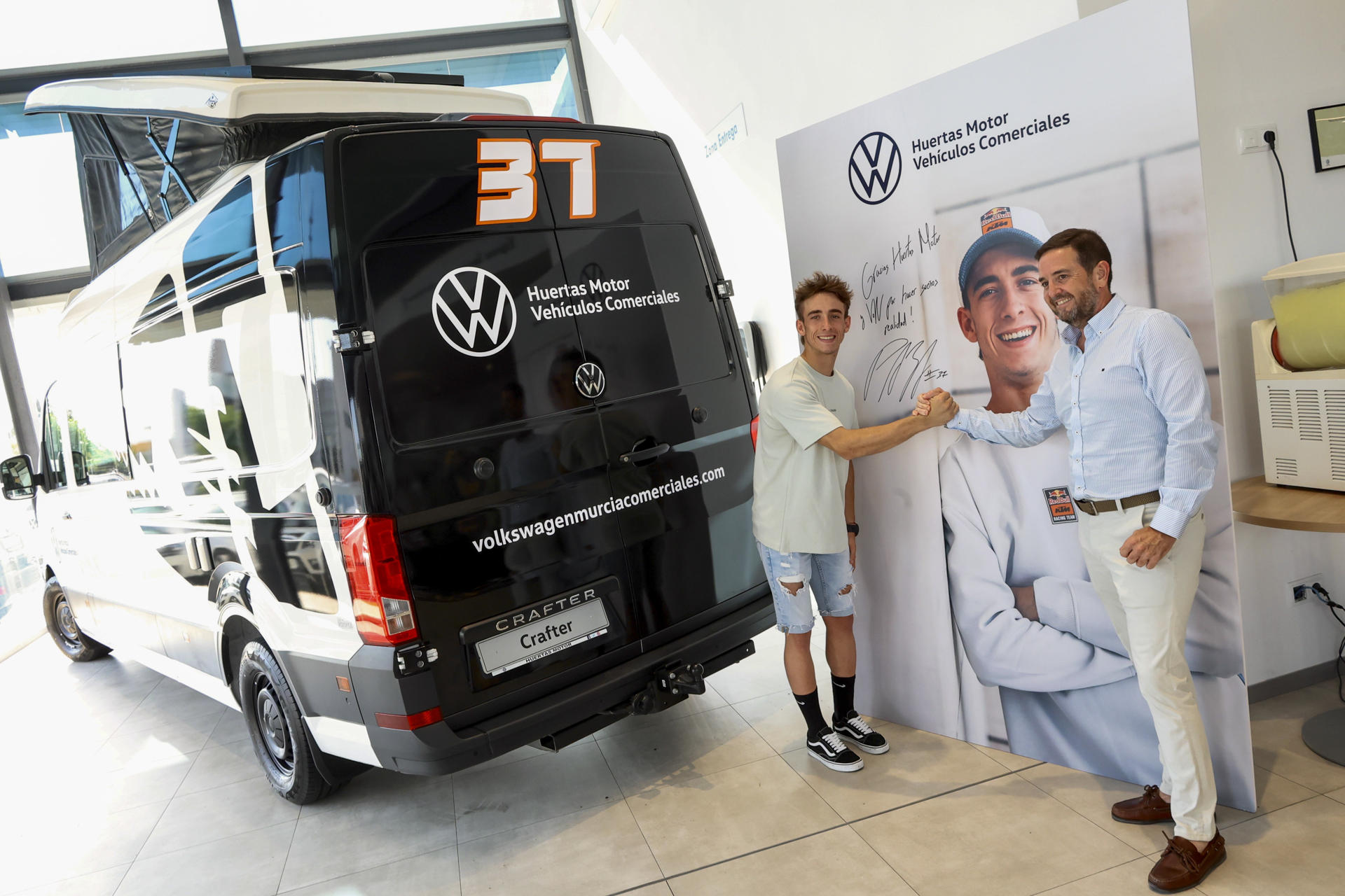 El piloto Pedro Acosta, junto a Enrique Ferrer (d), gerente del concesionario, en un evento para presentar oficialmente el acuerdo por el que Huertas Motor Volkswagen Vehículos Comerciales se convierte en socio de movilidad del piloto este miércoles, en Murcia. EFE/ Juan Carlos Caval

