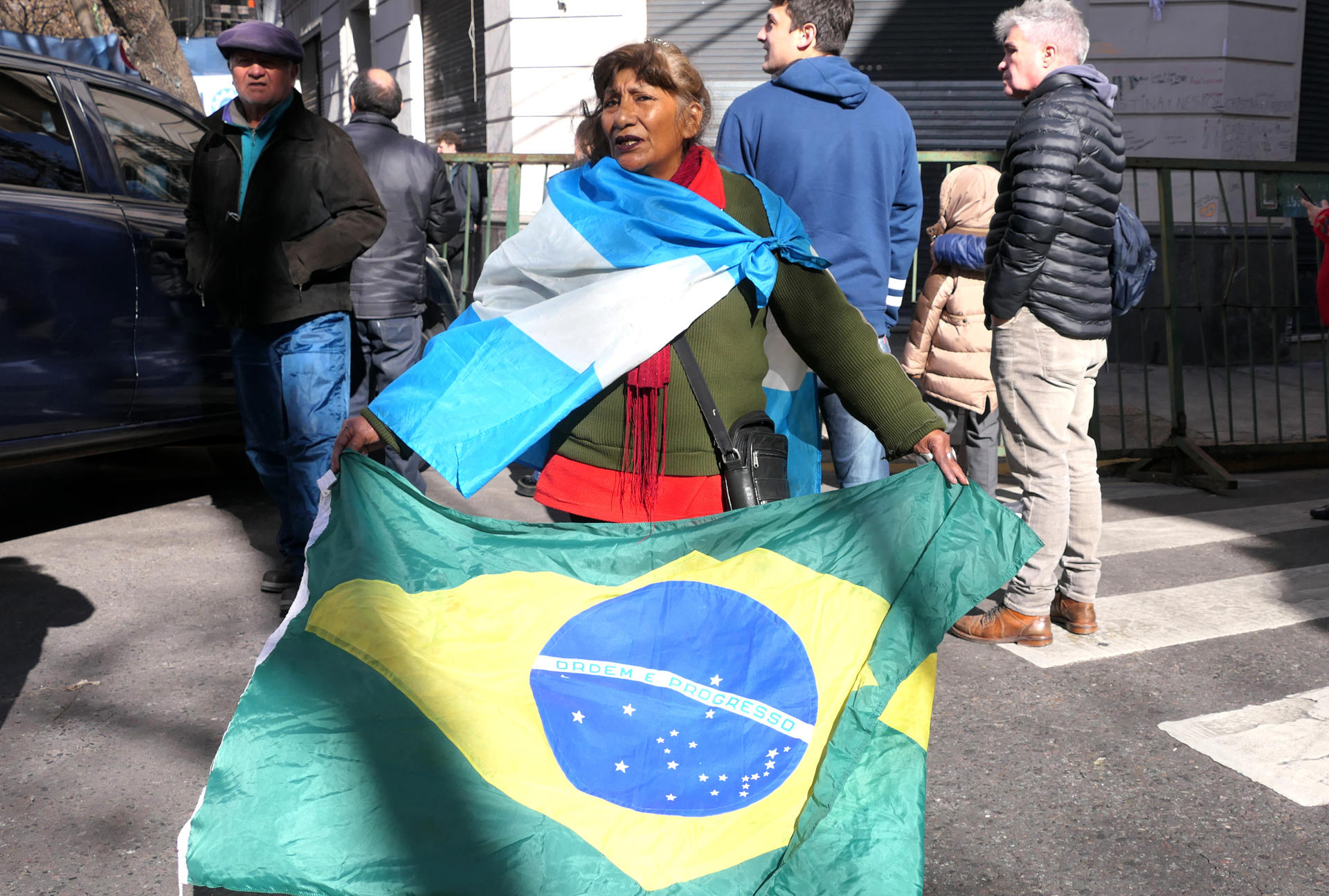 Una seguidora de la expresidenta argentina Cristian Fernández fue captada este jueves, 3 de julio, al portar banderas de Argentina y Brasil, a las afuera del edificio donde reside Fernández, quien cumple prisión domiciliaria y donde fue visitada por el presidente de Brasil, Luiz Inácio Lula da Silva, en Buenos Aires (Argentina).