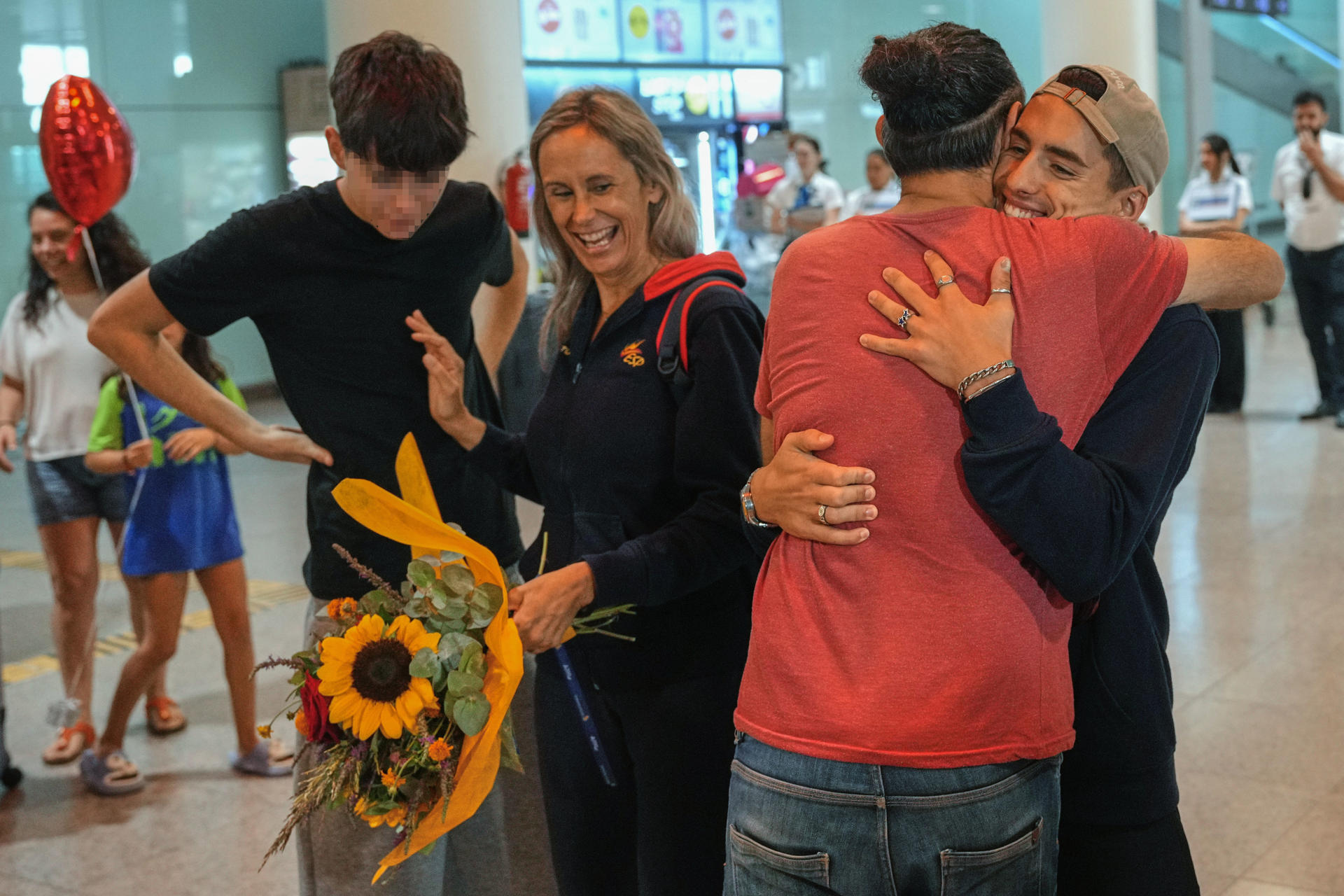 Llegada de Dennis González (d) con el grueso del equipo de natación artística al aeropuerto de El Prat. EFE/ Alejandro García