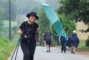 Peregrinos recorren el Camino Francés, protegidos de la lluvia, este viernes antes de su llegada a  Santiago de Compostela. EFE/ Xoán Rey.