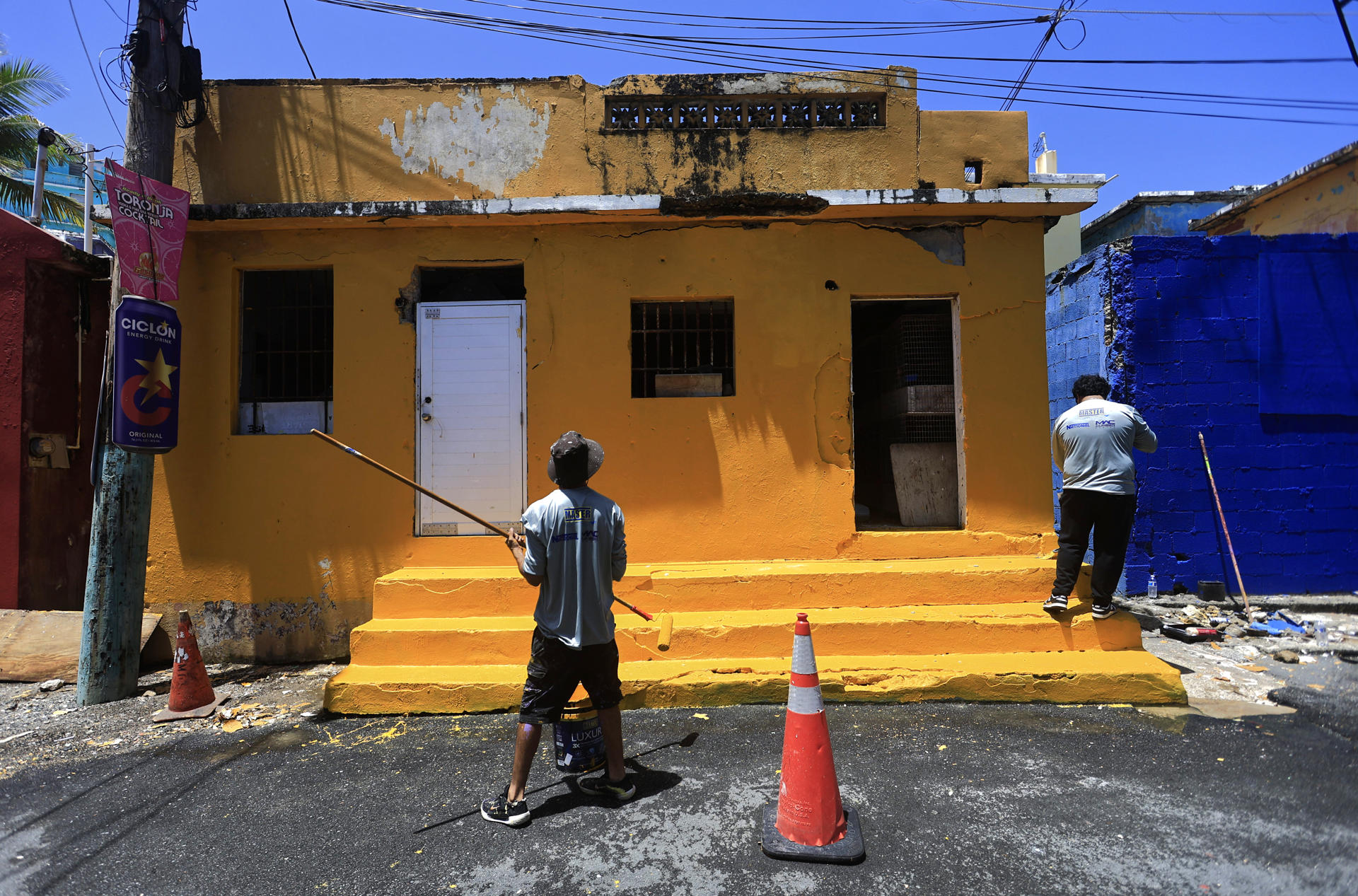 Personas pintan una casa en el marco de la iniciativa 'La Perla Pinta Su Futuro II' este miércoles, en la Perla en San Juan (Puerto Rico). EFE/ Thais Llorca