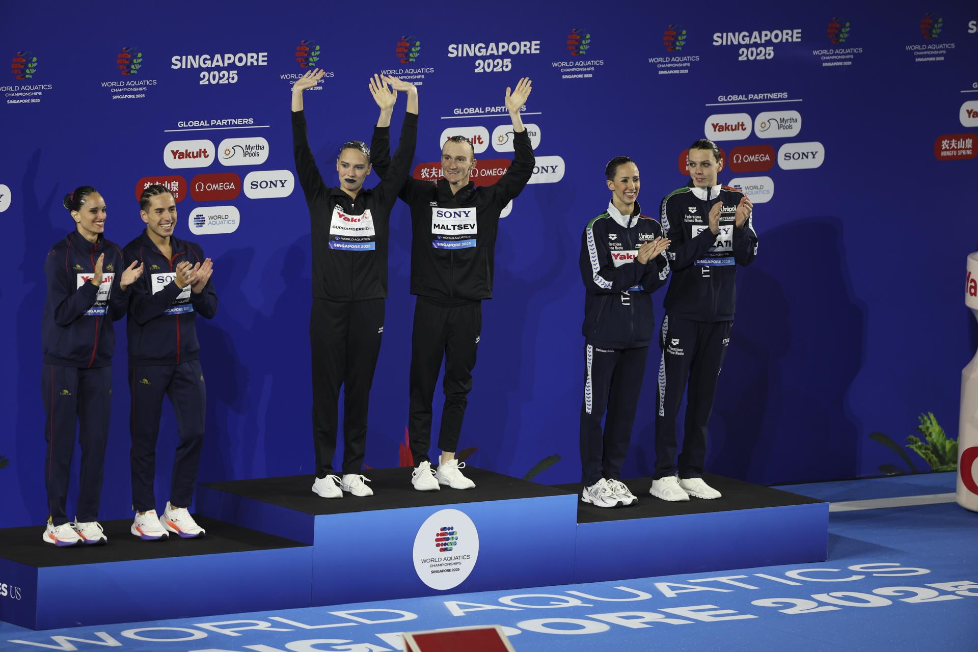 Los españoles Dennis González y Mireia Hernández (iz) celebran en el podio la plata en rutina técnica del dúo mixto. El oro fue para los rusos Mayya Gurbanberdieva y Aleksandr Maltsev y el bronce para los italianos Lucrezia Ruggiero y Filippo Pelati. EFE/EPA/FAZRY ISMAIL