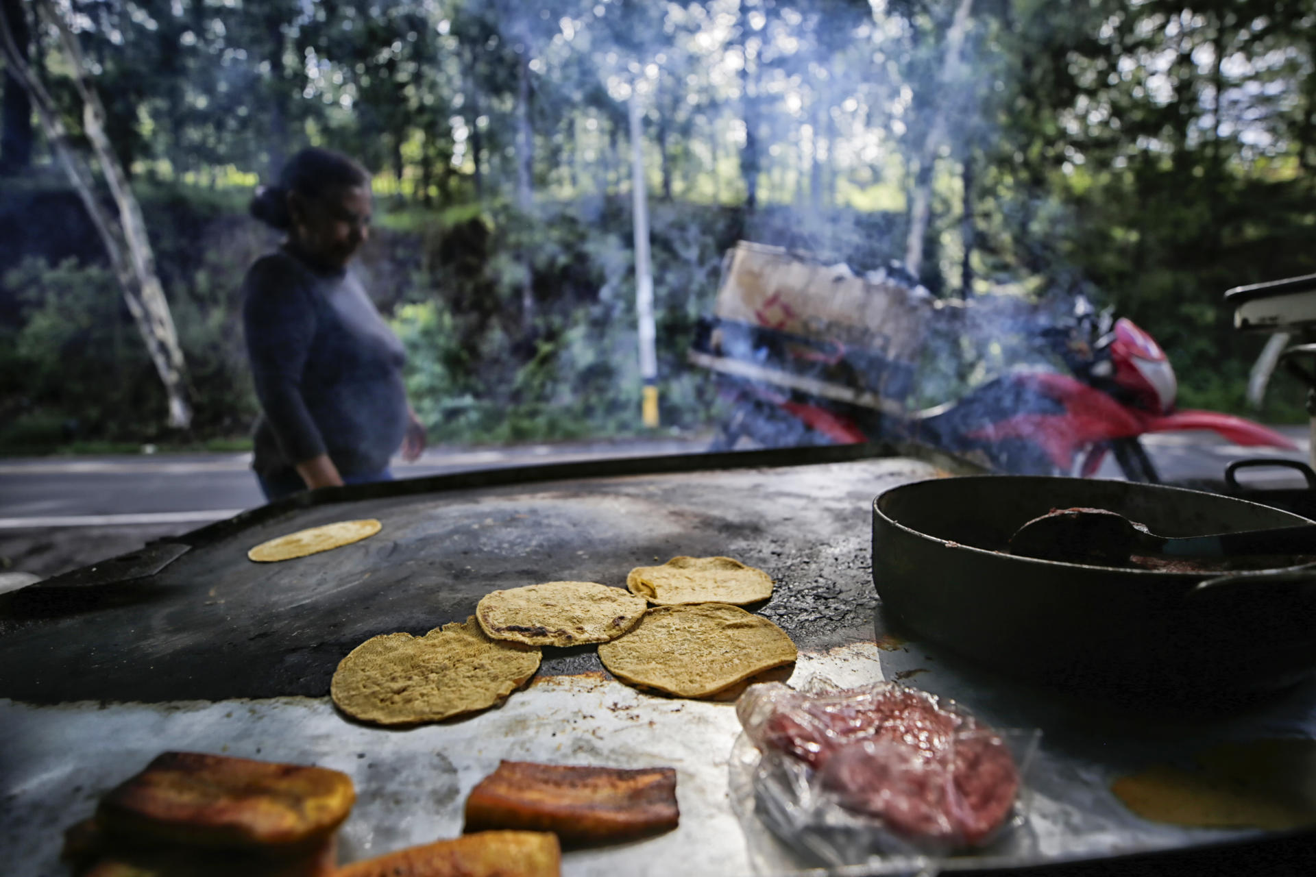 Una persona prepara alimentos este martes en Santa Lucía (Honduras). EFE/ Gustavo Amador