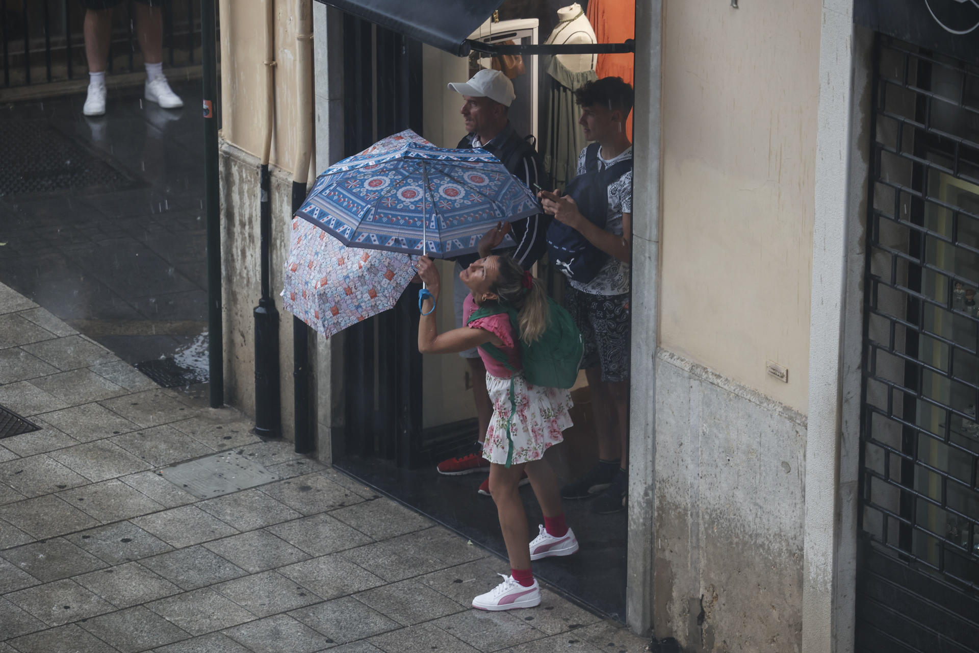 Varias personas se protegen de la lluvia este jueves en València. Aemet ha establecido el aviso amarillo por lluvia y tormentas en Alicante y Valencia este jueves y también por fenómenos costeros en Alicante. EFE/ BIEL ALIÑO
