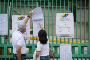 Personas revisan la lista de votación durante las elecciones municipales y concejales este domingo, en Caracas (Venezuela). EFE/ Boris Vergara