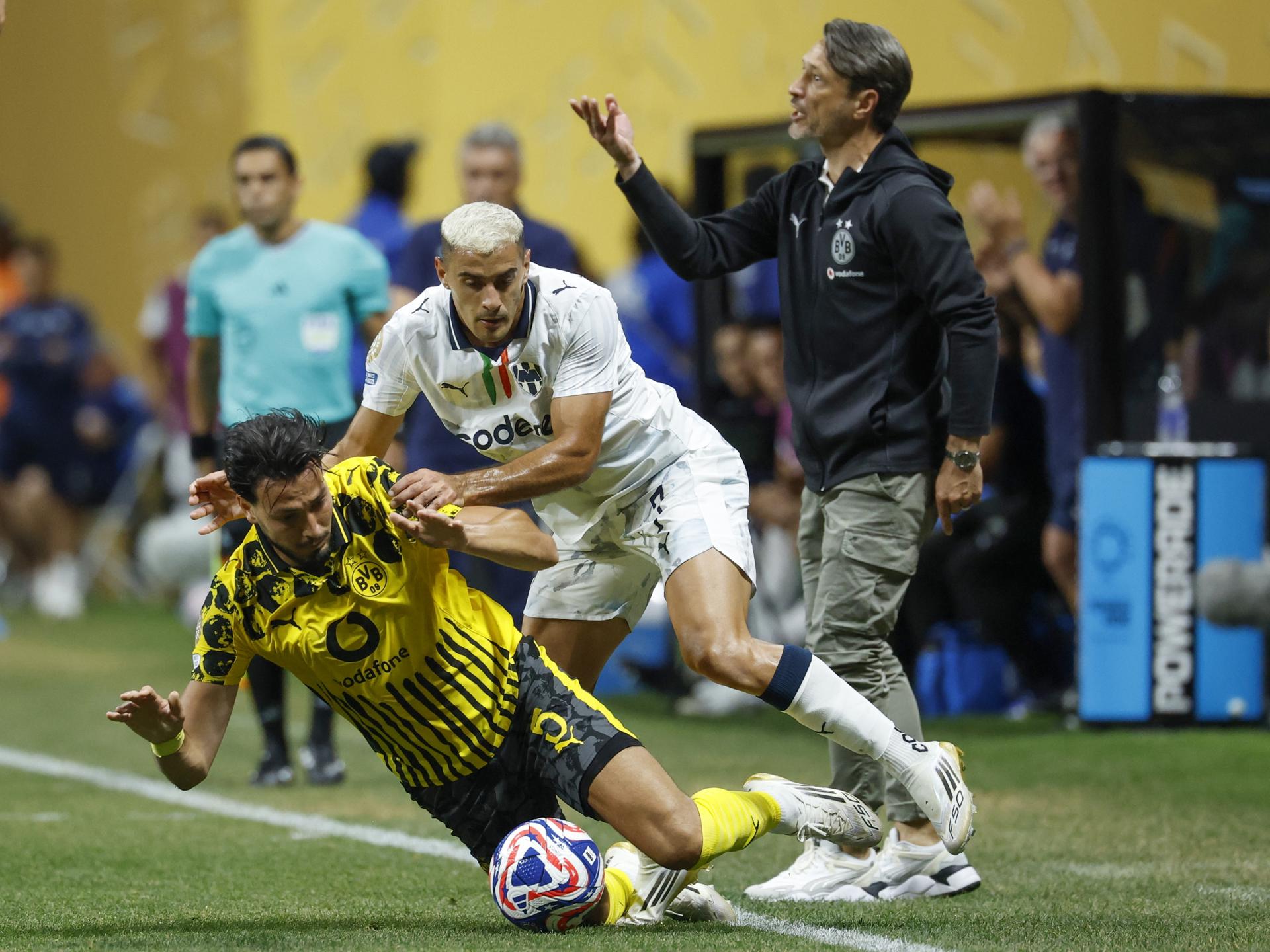Ramy Bensebaini (i), del Borussia Dortmund, y Germán Berterame, del Monterrey, disputan el balón. EFE/EPA/ERIK S. LESSER
