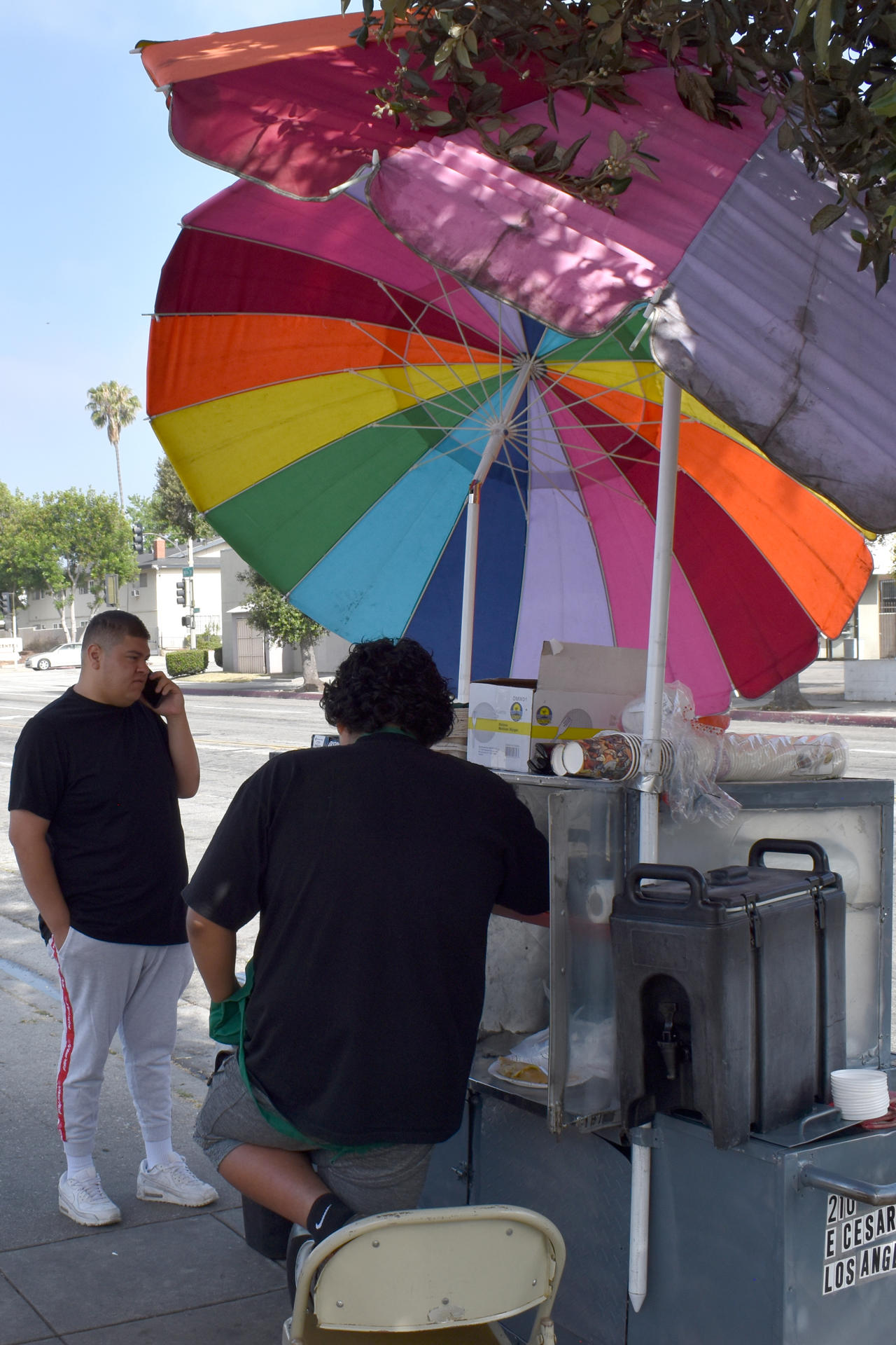 Chris (c), un niño de 14 años, fue captado el pasado 2 de julio al trabajar en un puesto de tamales que su mamá teme atender, por miedo a las redadas migratorias que adelanta la Administración Trump, en Pasadena (CA, EE.UU.). EFE/Mónica Rubalcava